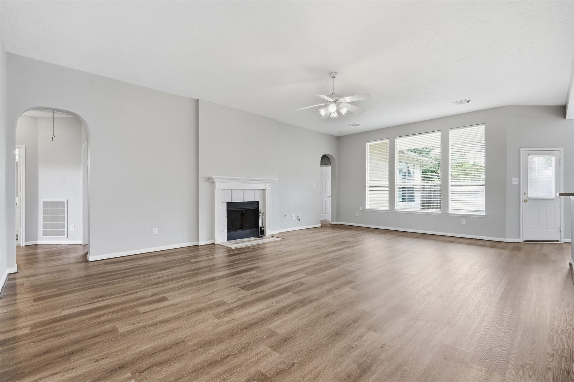 3003 Grey Mist Court, Friendswood, TX 77546 Spacious living area with updated flooring, wood burning fireplace and plenty of natural light.