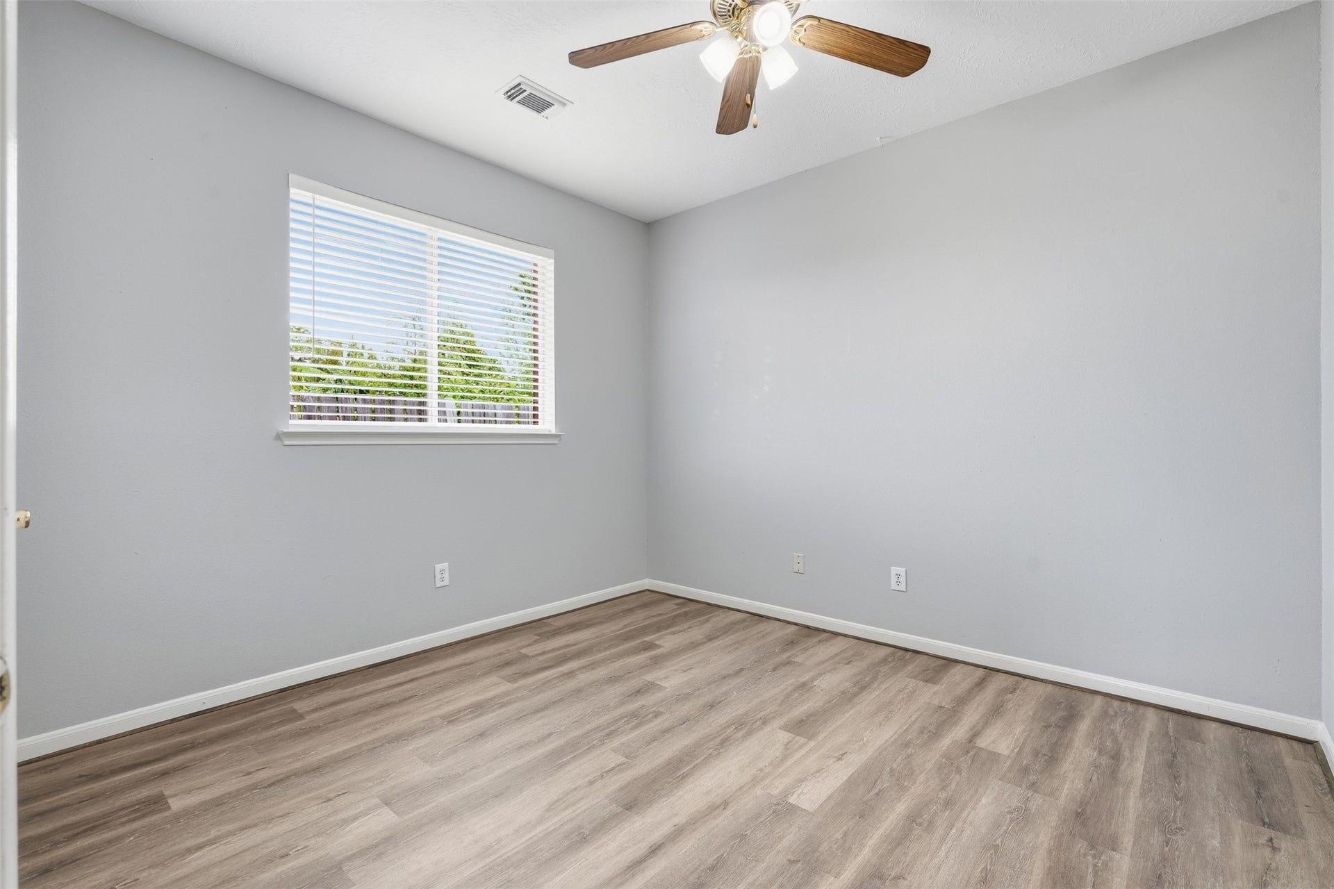 3003 Grey Mist Court, Friendswood, TX 77546 Generously sized secondary bedroom with updated flooring and natural light.