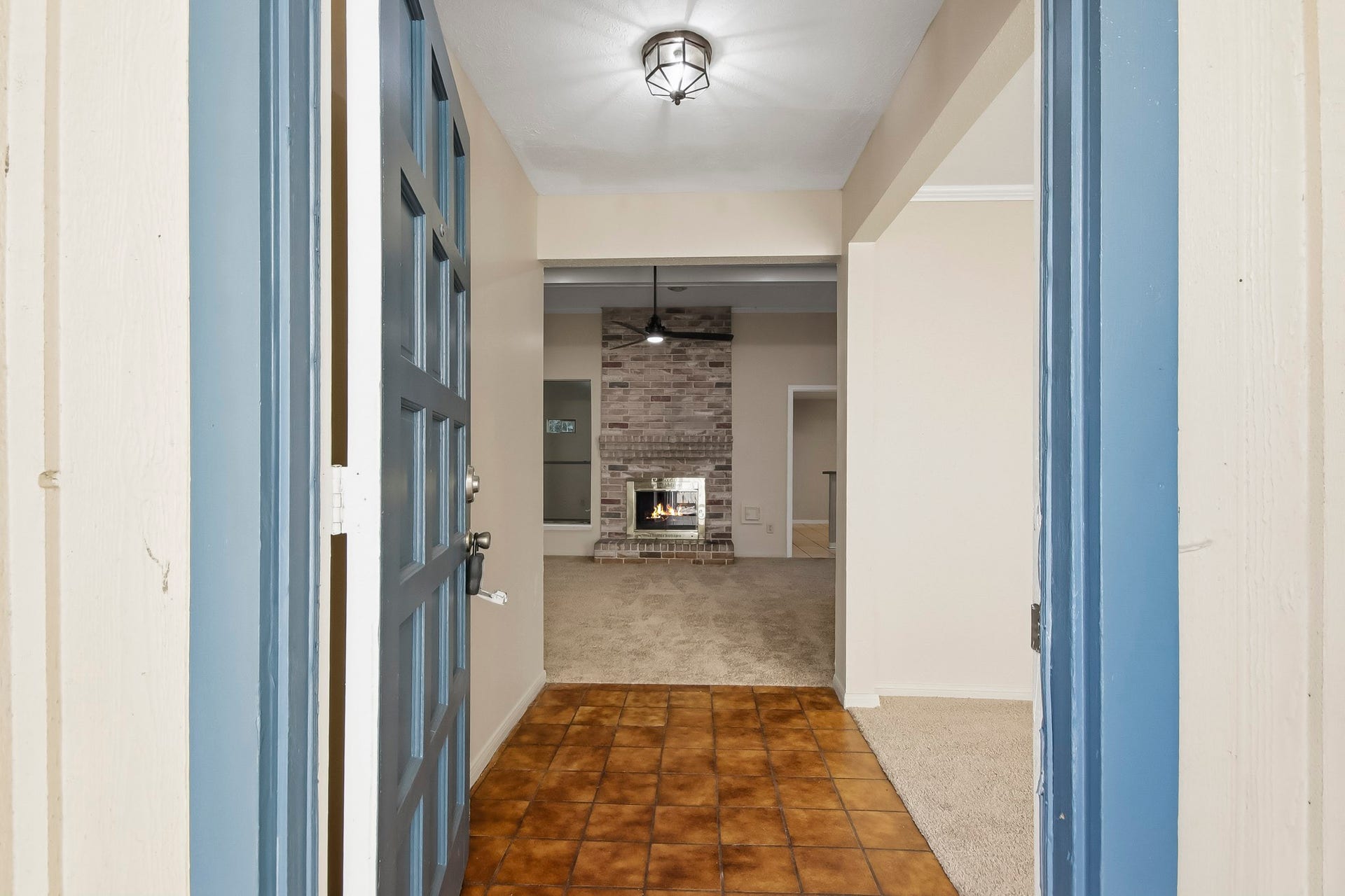 8807 Lakeside Forest Drive, Houston, TX 77088 Step inside to a tiled entryway leading into the living room, featuring a brick fireplace.