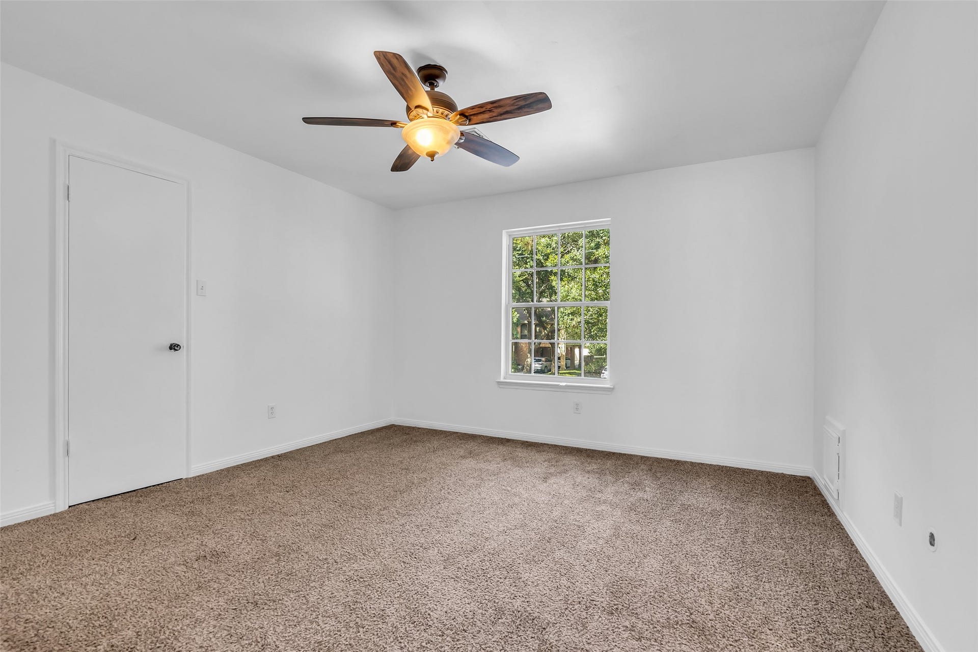 14014 Court Of Regents, Houston, TX 77069 Another bedroom on the second floor overlooking the front lawn, featuring carpeted flooring and a ceiling fan, ready to be styled to suit your personal taste.