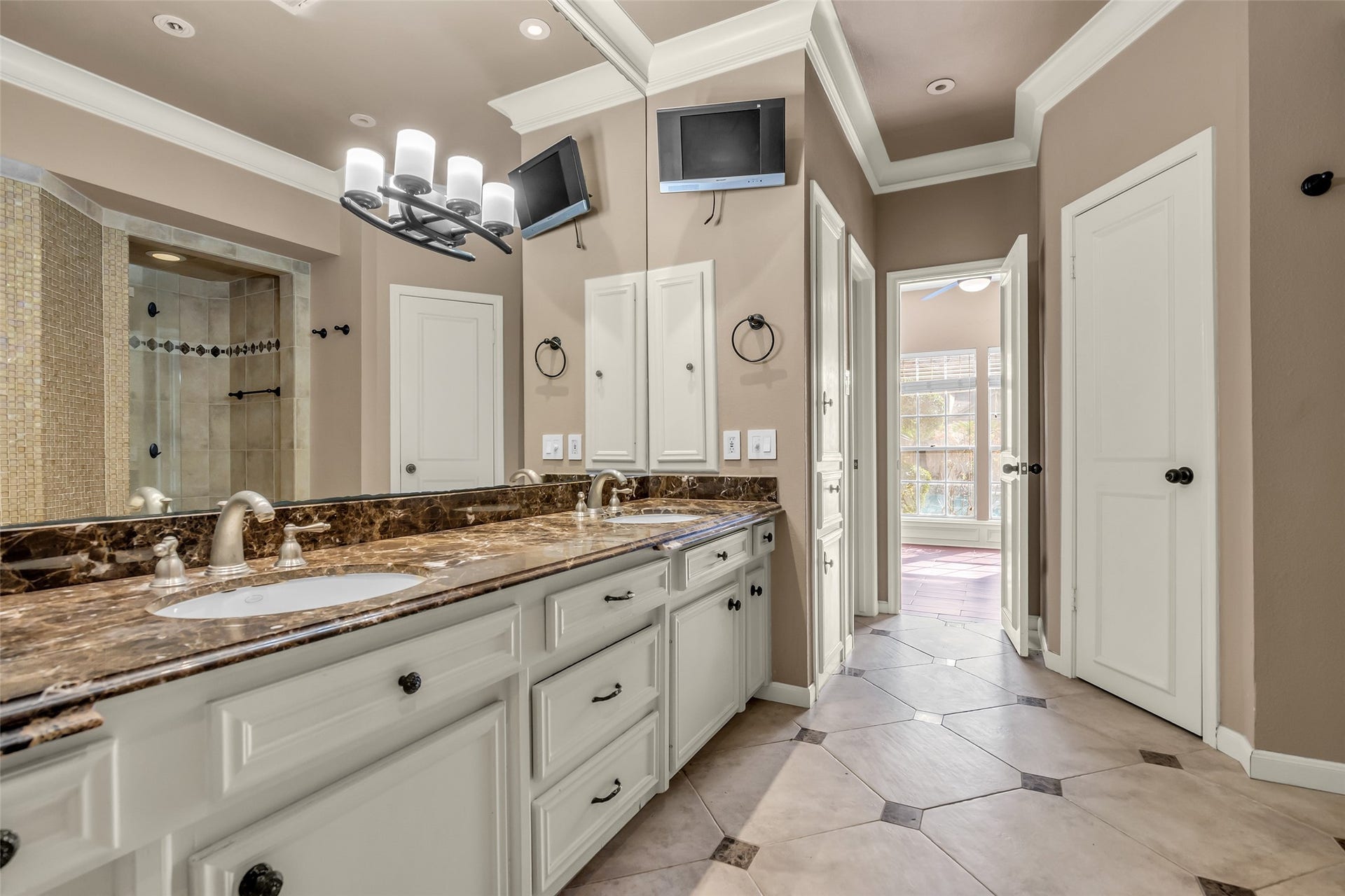 14014 Court Of Regents, Houston, TX 77069 It has dual vanities offering ample counter space and storage. A large walk-in shower serves as the centerpiece, enclosed with frameless glass and finished with elegant tilework for a clean, upscale look.