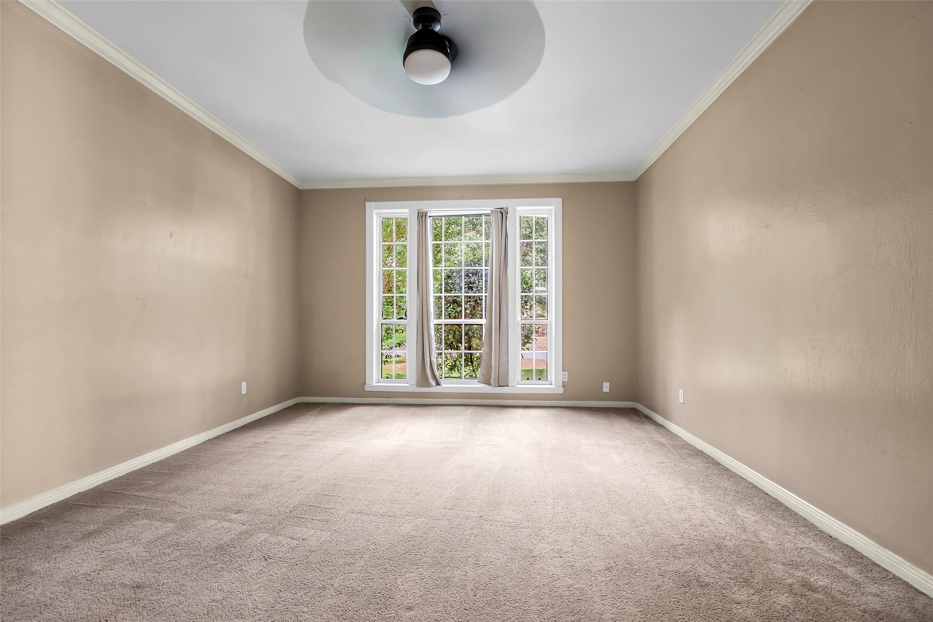 14014 Court Of Regents, Houston, TX 77069 Main bedroom faces the front lawn and features a carpeted floor. A large window fills the room with natural light, creating a bright and comfortable retreat.
