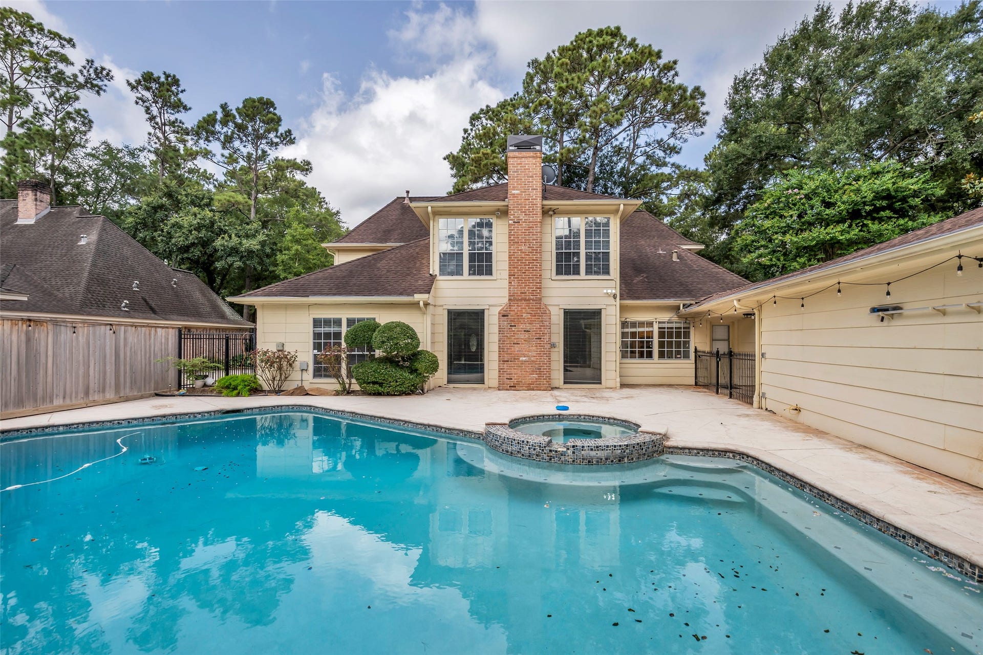 14014 Court Of Regents, Houston, TX 77069 Features an in-ground pool with an attached hot tub, creating a versatile space for outdoor enjoyment.