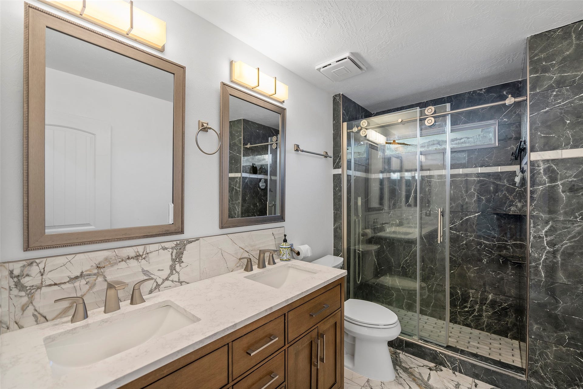 Spacious second-floor full bathroom featuring a double vanity and a fully remodeled walk-in shower.