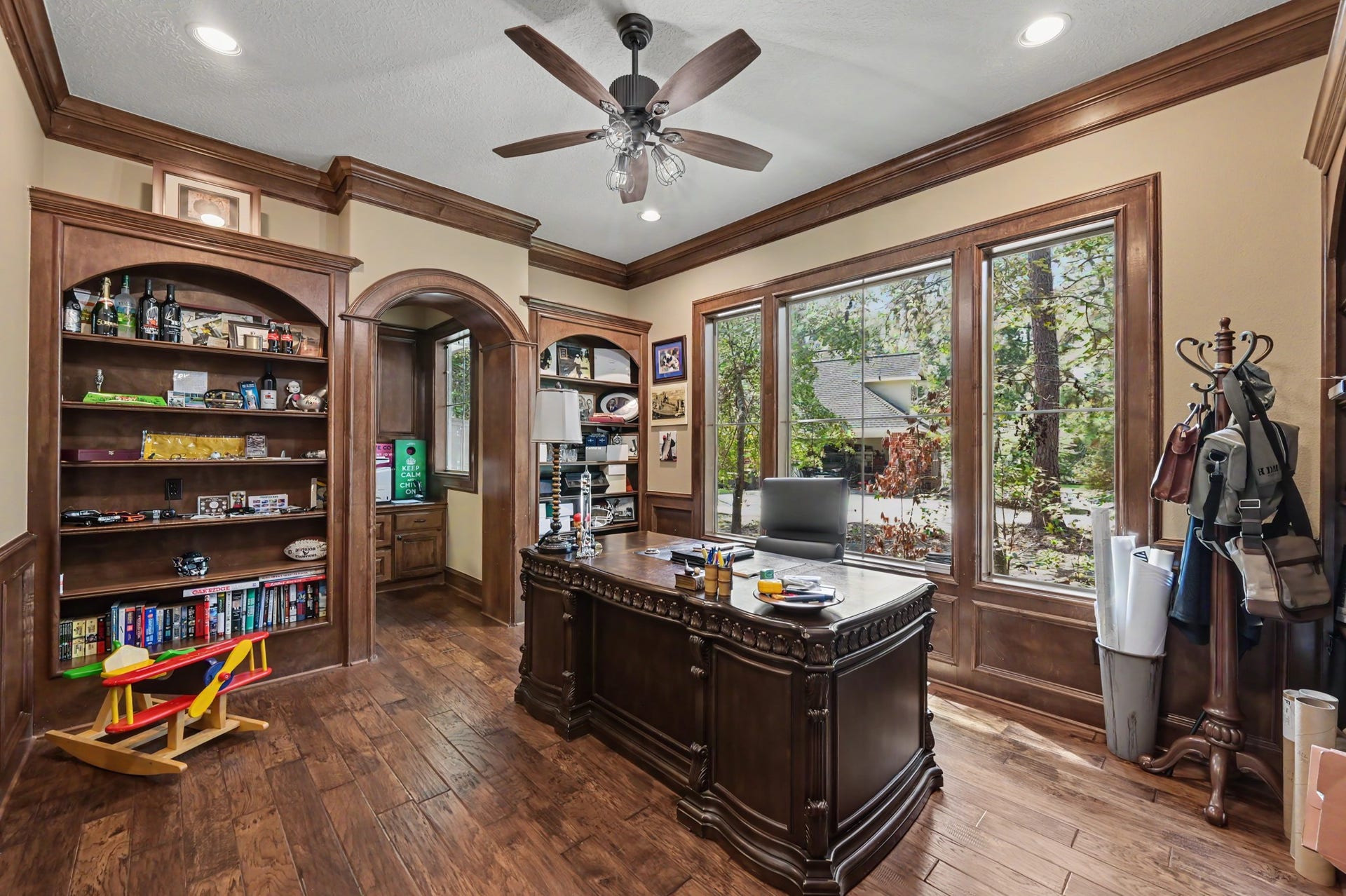27706 Braydon Court, Spring, TX 77386 Sophisticated home office/study/library with rich wood detailing, large windows providing natural light, and built-in shelving.