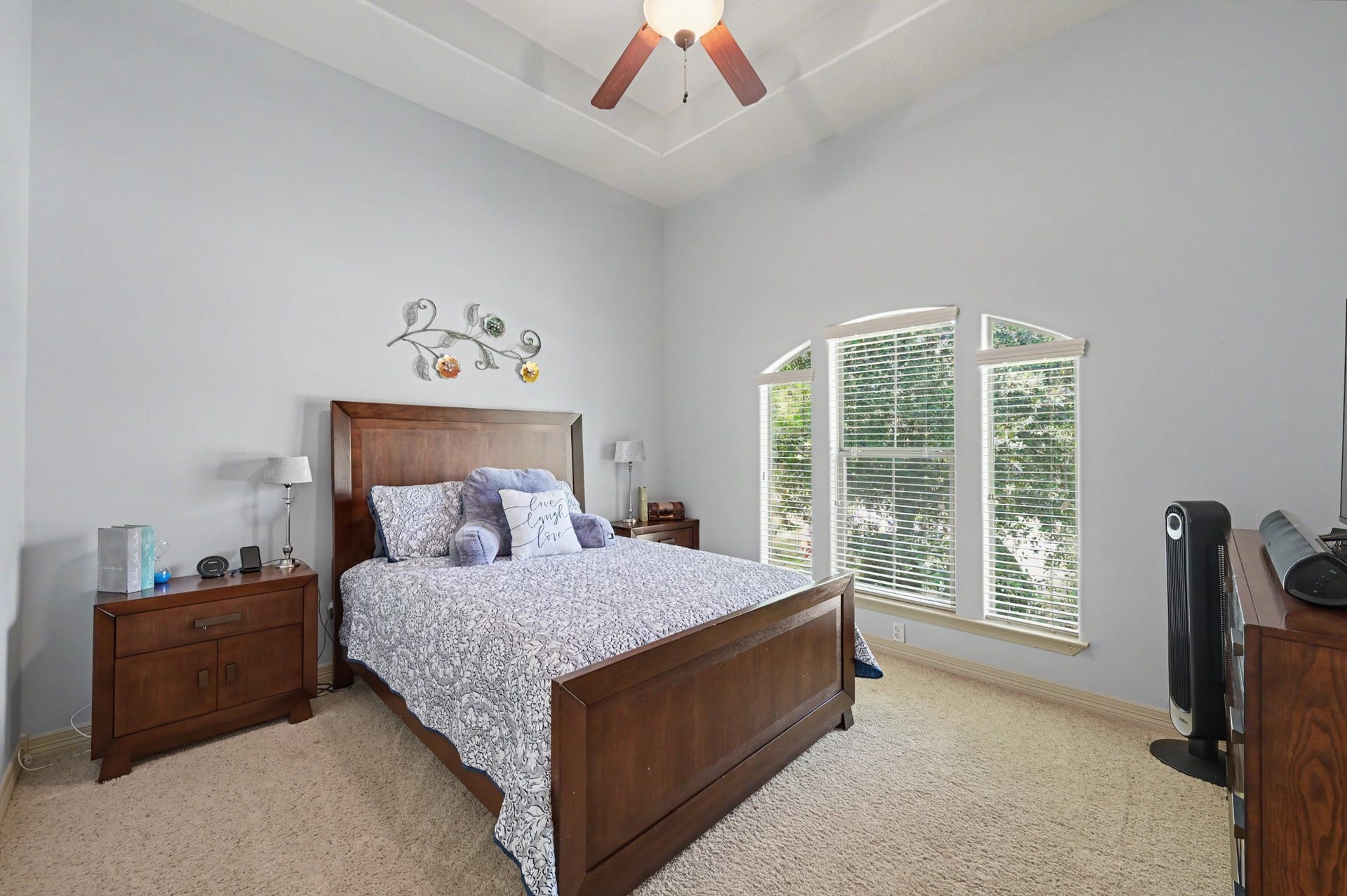 27706 Braydon Court, Spring, TX 77386 Spacious bedroom with a vaulted ceiling, large arched windows for natural light, and elegant wood furniture creating a cozy, inviting atmosphere.
