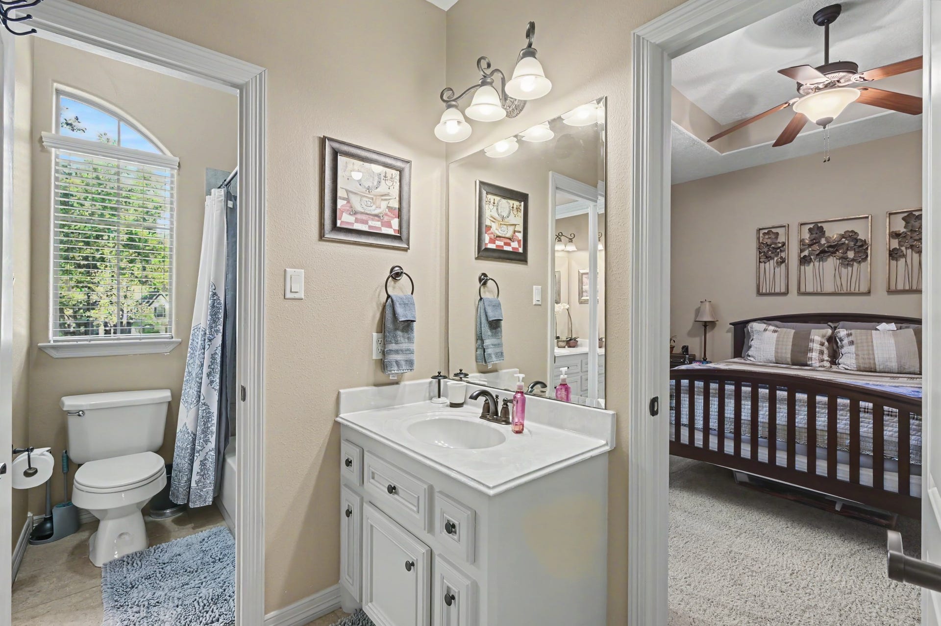 27706 Braydon Court, Spring, TX 77386 Charming ensuite bathroom featuring a stylish vanity with ample storage, adjacent to a cozy bedroom with elegant decor and a ceiling fan.