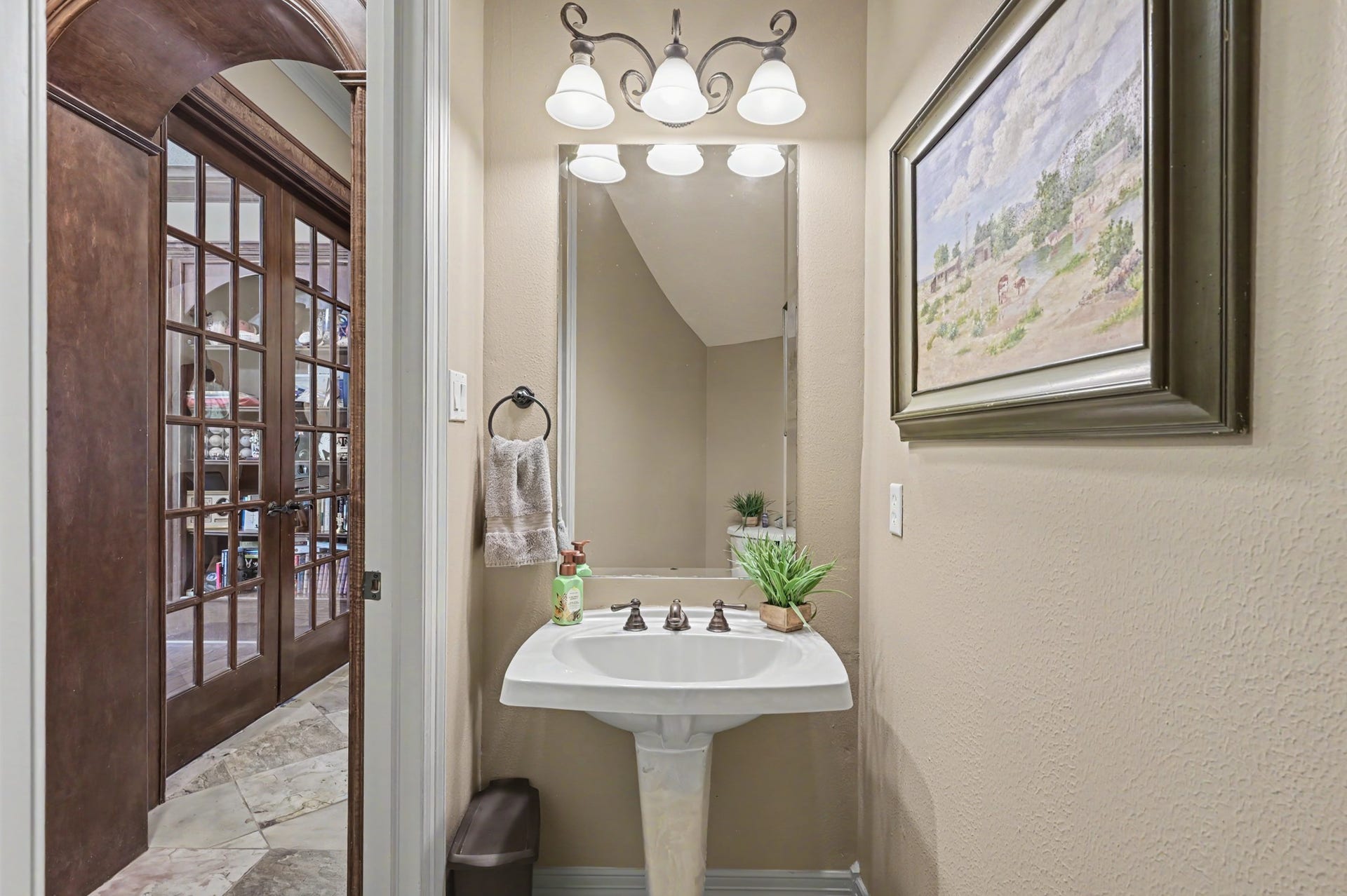 27706 Braydon Court, Spring, TX 77386 Charming, first floor powder room with a pedestal sink, framed mirror, and tasteful lighting, conveniently located next to a front door and home office/study/library.