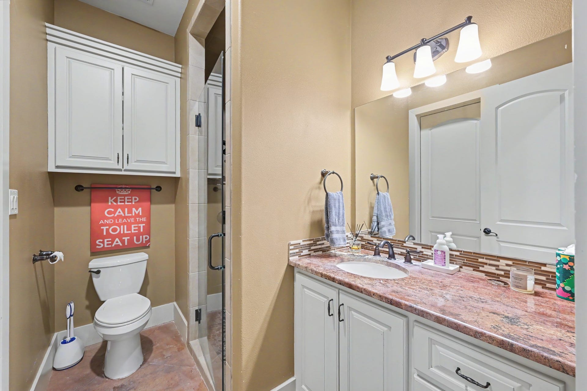 27706 Braydon Court, Spring, TX 77386 Elegant bathroom with a spacious vanity, granite countertop, and stylish lighting. Features a glass-enclosed shower and ample cabinet storage.