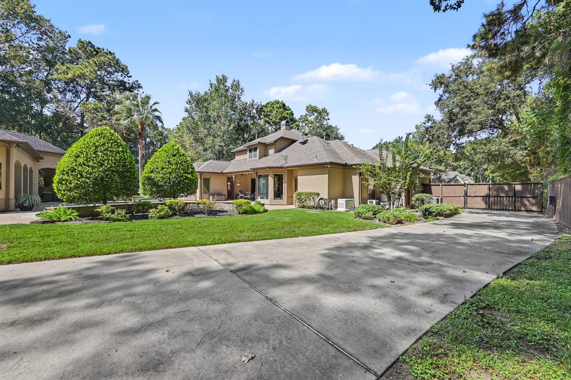 27706 Braydon Court, Spring, TX 77386 Elegant two-story home surrounded by lush greenery, featuring a spacious driveway and well-manicured garden beds for an inviting curb appeal.