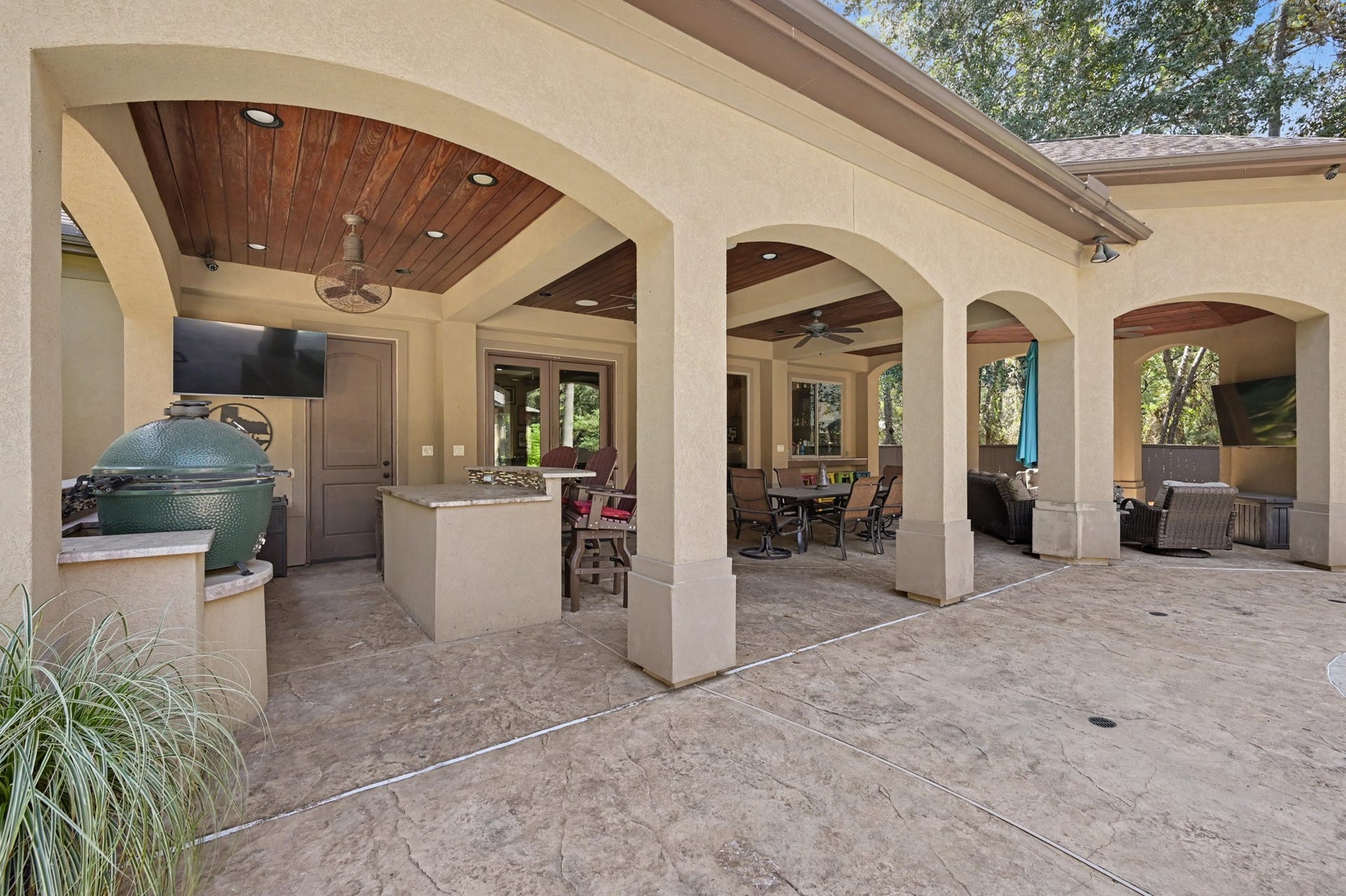 27706 Braydon Court, Spring, TX 77386 Elegant outdoor living space featuring covered patios, a built-in grill, and ample seating, perfect for entertaining and relaxation.