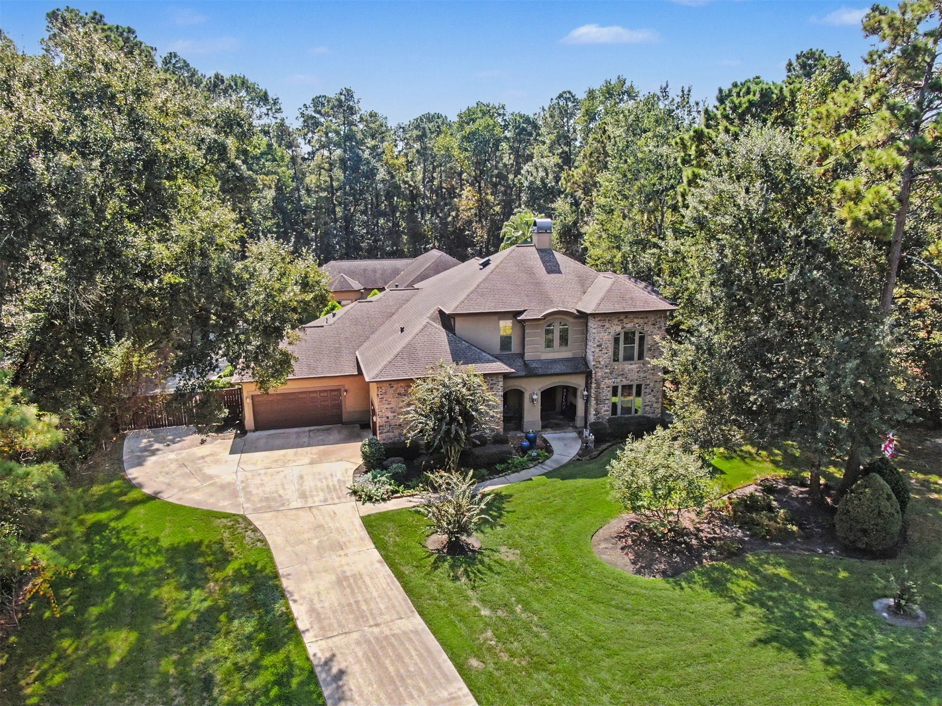 27706 Braydon Court, Spring, TX 77386 Stunning two-story home nestled among mature trees, featuring a spacious driveway and beautifully landscaped yard, offering both privacy and elegance.