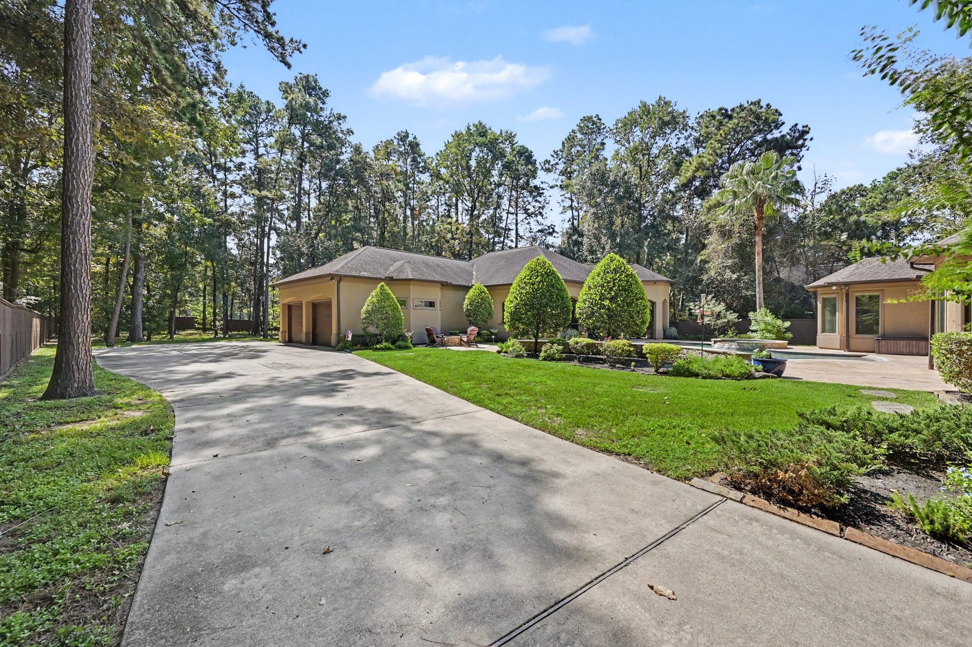27706 Braydon Court, Spring, TX 77386 Spacious single-story home with a beautifully landscaped front yard and a long driveway, nestled among mature trees for a serene and private setting.