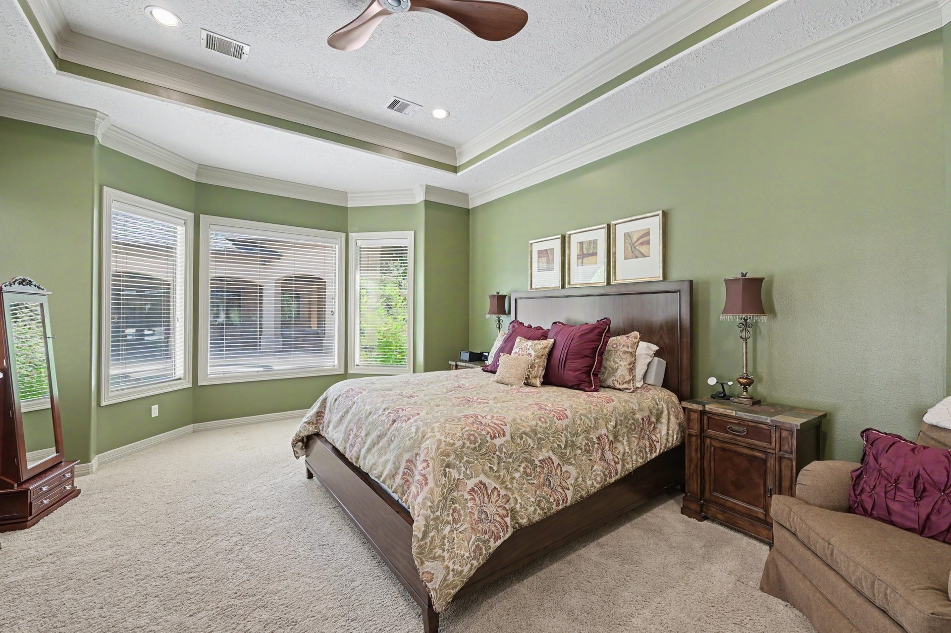 27706 Braydon Court, Spring, TX 77386 Huge primary bedroom with elegant tray ceiling, large bay windows for natural light, and soothing green walls, creating a tranquil retreat.