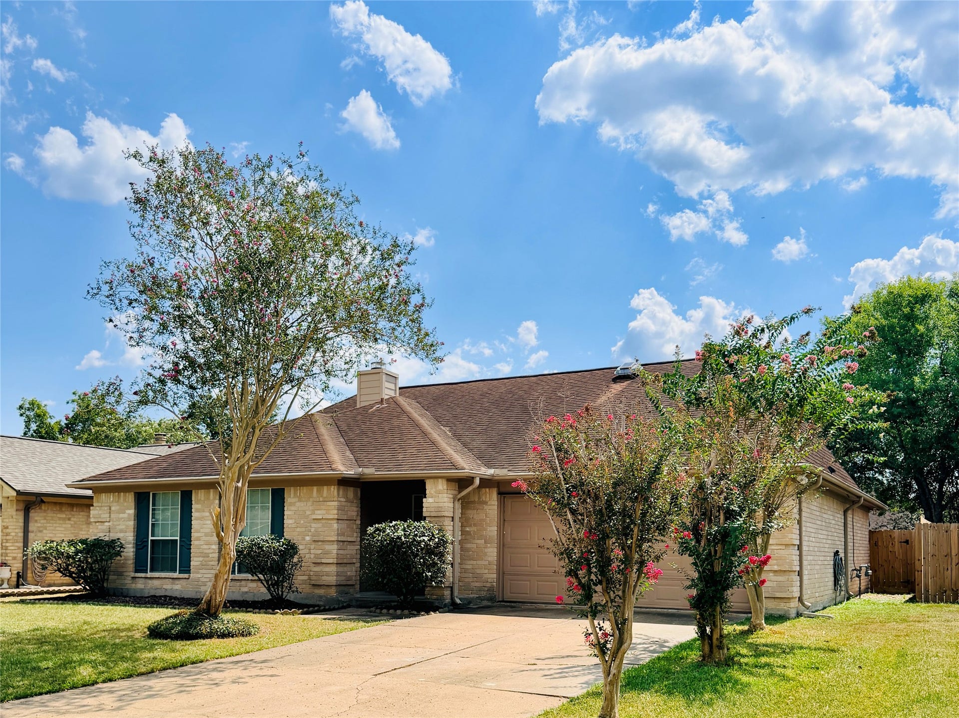 15051 Felgate Creek Drive, Houston, TX 77084 Front exterior view showcasing the home's brick faade, mature landscaping, two-car garage, and extended driveway.