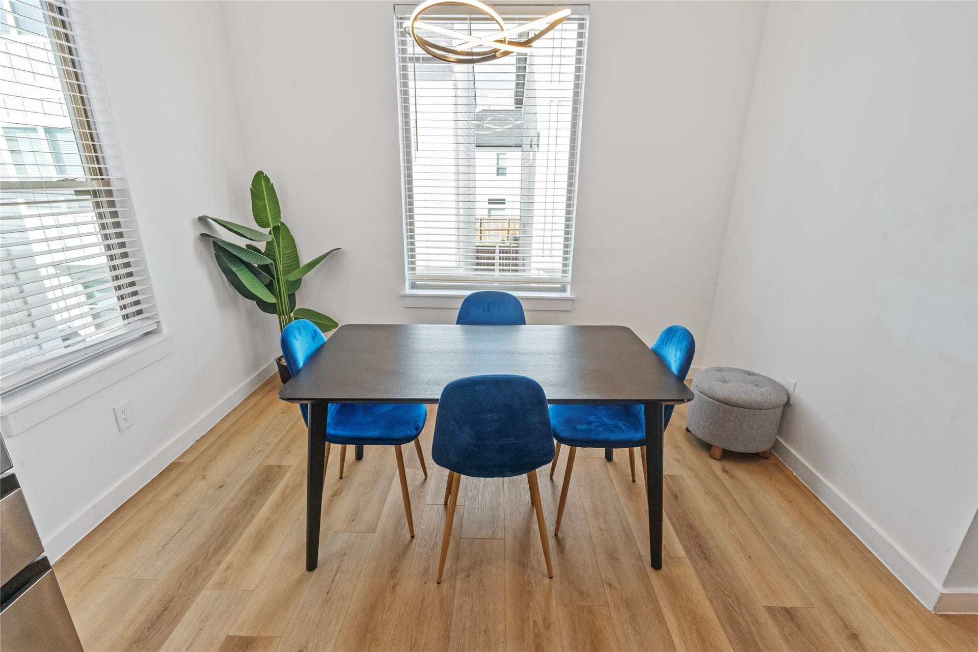 6742 Peerless Street, #B, Houston, TX 77021 Sunlit dining space is framed by windows on two sides, creating a bright setting for everyday meals or entertaining. Contemporary lighting and warm wood look flooring complement the open connection to the kitchen and living areas.