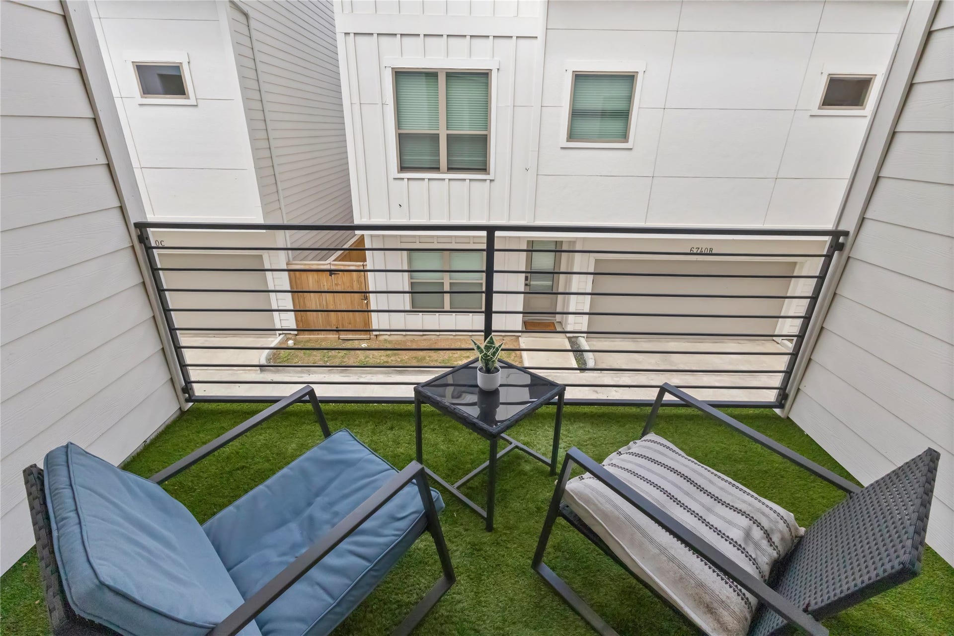 6742 Peerless Street, #B, Houston, TX 77021 Step outside to a covered private balcony with space for morning coffee or an evening unwind. Low maintenance turf flooring and sleek metal railings create a comfortable outdoor retreat just off the main living area.