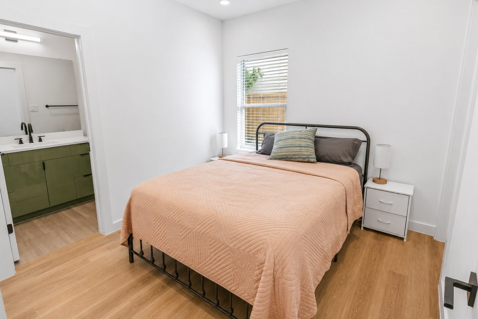 6742 Peerless Street, #B, Houston, TX 77021 Private first floor bedroom offers a quiet retreat with warm wood look flooring, abundant natural light, and direct access to its own en suite bath. Ideal for overnight guests, a home office, or multigenerational living, the layout provides comfort and flexibility while maintaining privacy from the main living areas.