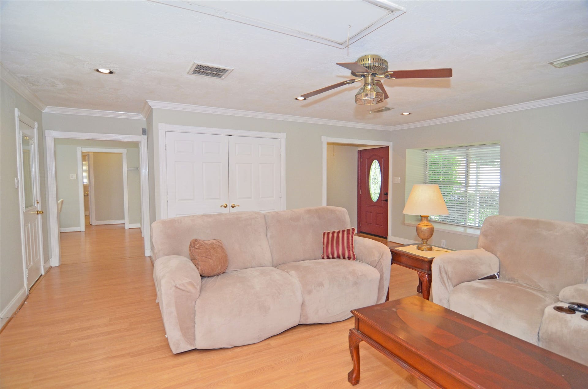 2719 Sweetgum Street, Pasadena, TX 77502 Spacious and inviting living room with crown molding, abundant natural light, and a cozy ceiling fan. Perfect for relaxation and entertaining.