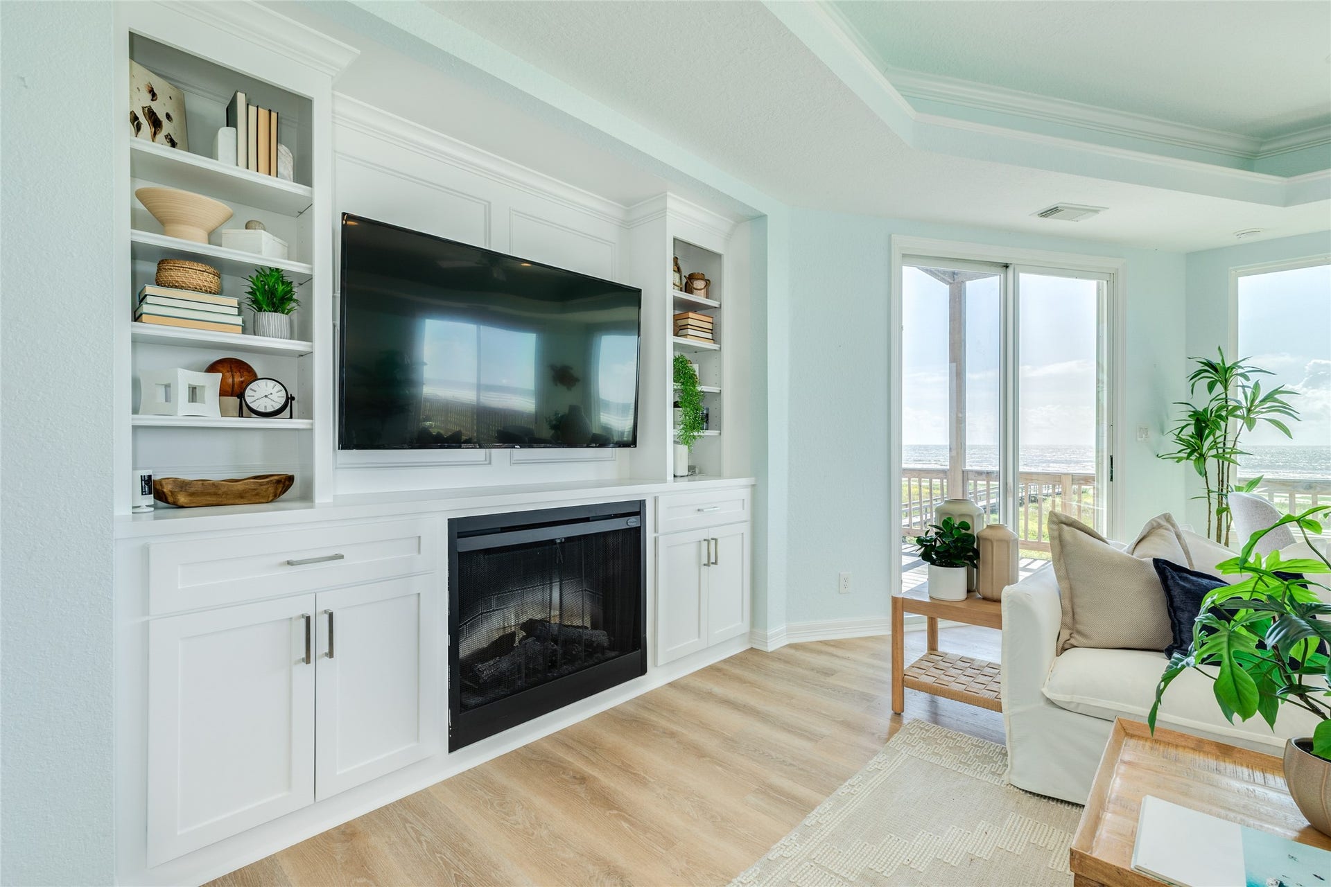 20911 W Sand Hill Drive, Galveston, TX 77554 Living Room features an electric fireplace and built-in bookshelves with cabinets