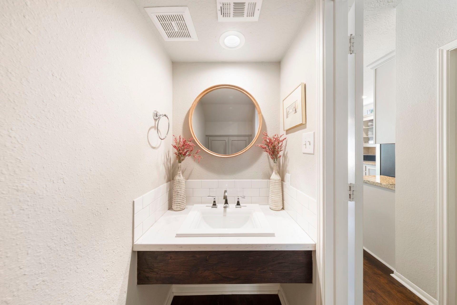 6 N Cochrans Green Circle, The Woodlands, TX 77381 Beautifully updated powder bath with a floating reclaimed-wood vanity, quartz countertop, subway tile, and polished fixtures.