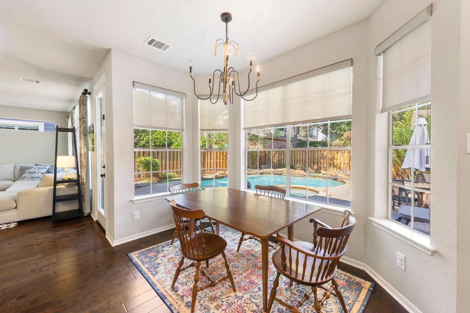 6 N Cochrans Green Circle, The Woodlands, TX 77381 Airy breakfast nook wrapped in oversized windows with custom shades, offering picturesque views of the sparkling pool and spa.