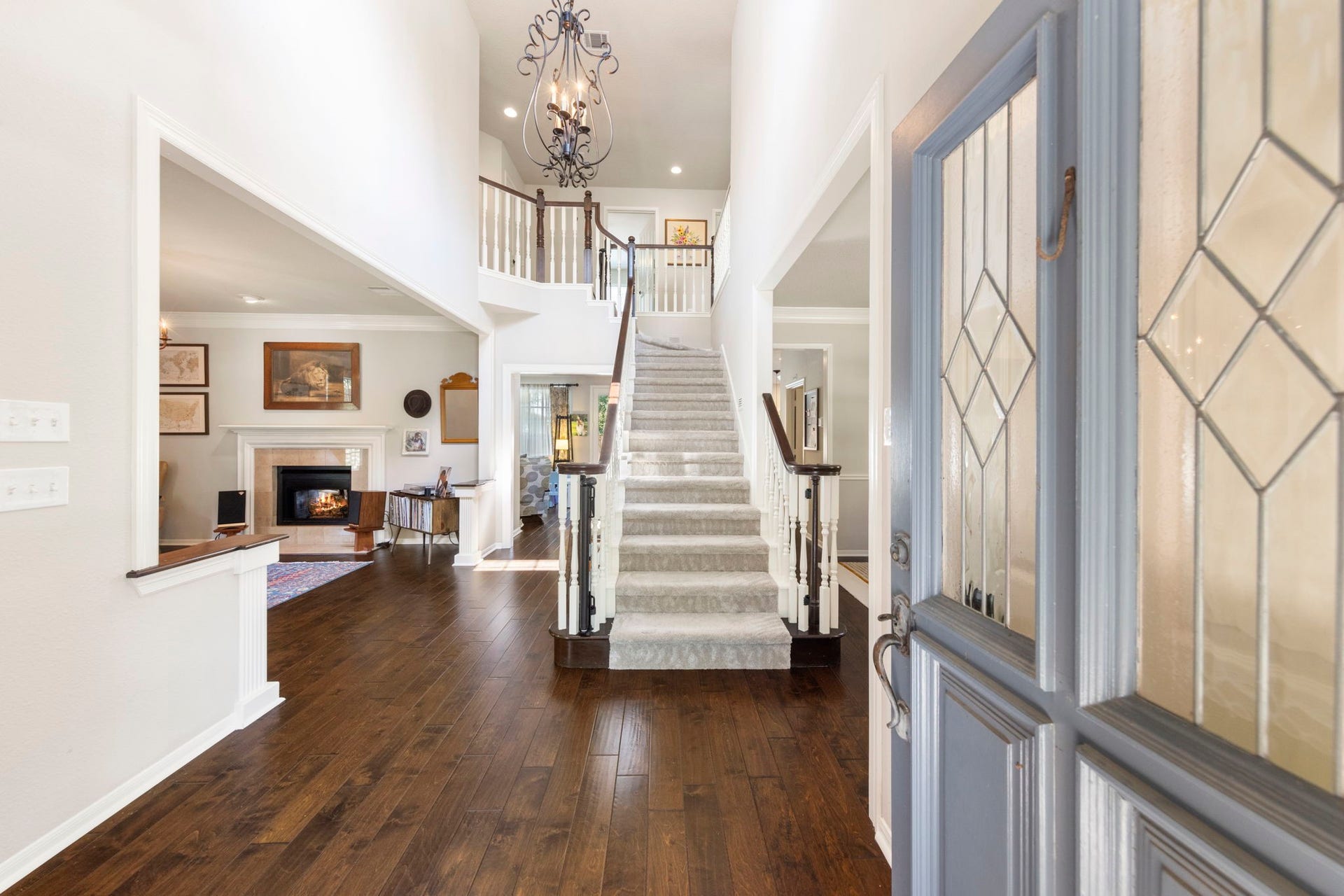 6 N Cochrans Green Circle, The Woodlands, TX 77381 Soaring two-story foyer crowned by a wrought-iron chandelier, rich hand-scraped hardwoods, and a stately staircase with dark-stained rails.