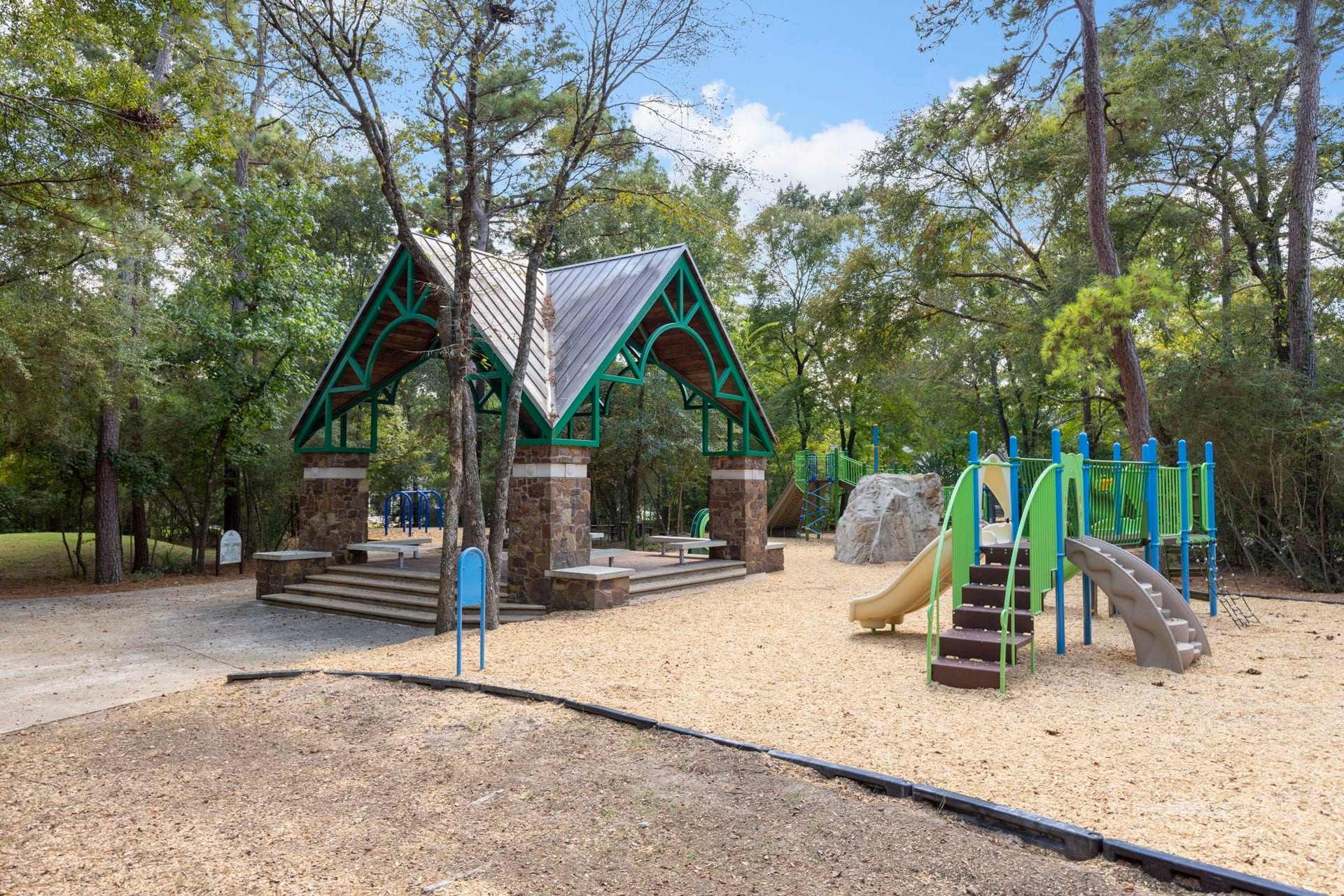 6 N Cochrans Green Circle, The Woodlands, TX 77381 Nearby park with a charming stone-and-timber pavilion and playground, nestled beneath towering pines.