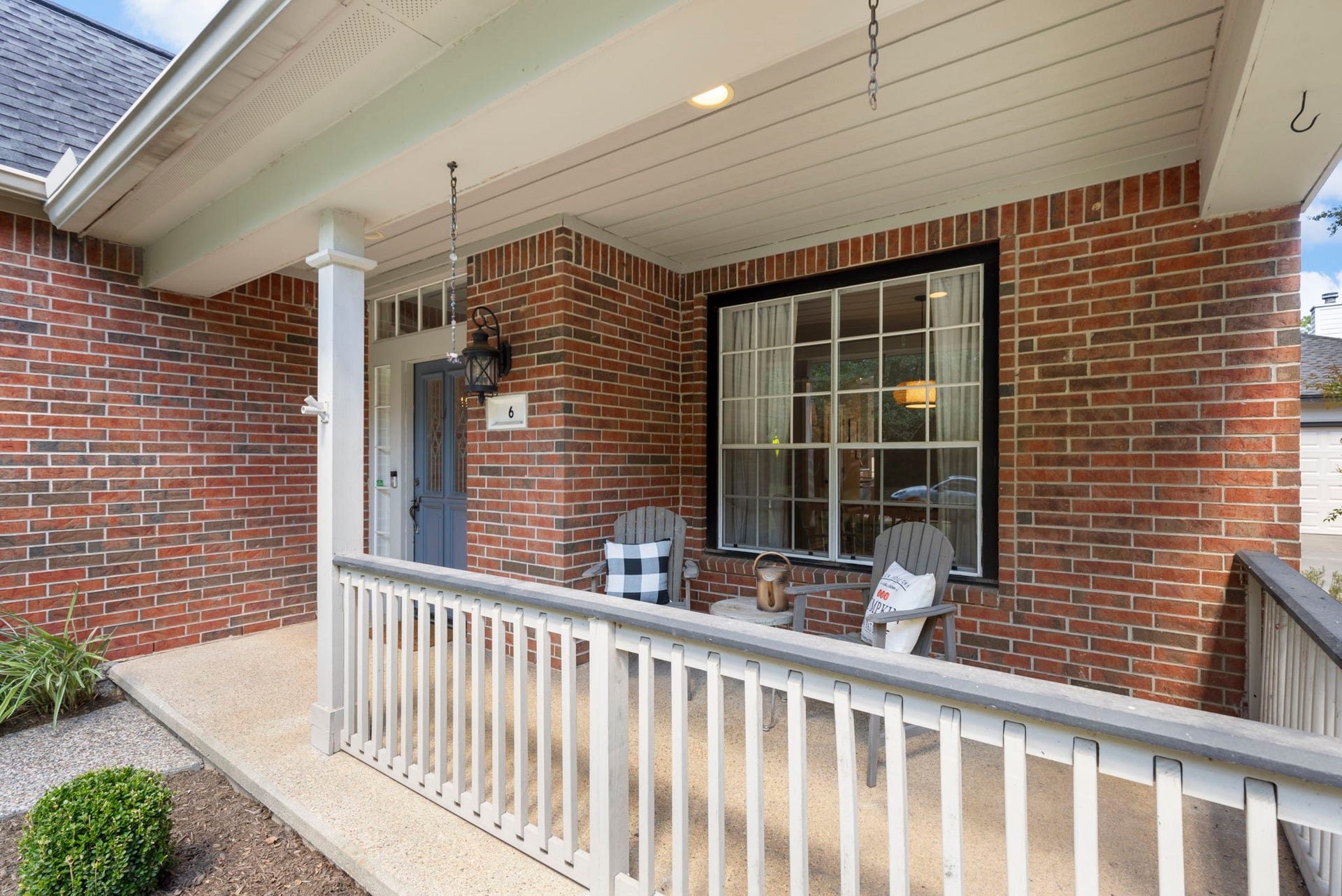 6 N Cochrans Green Circle, The Woodlands, TX 77381 Covered porch with crisp white railings and recessed lighting, an inviting perch for morning coffee or evening conversation.