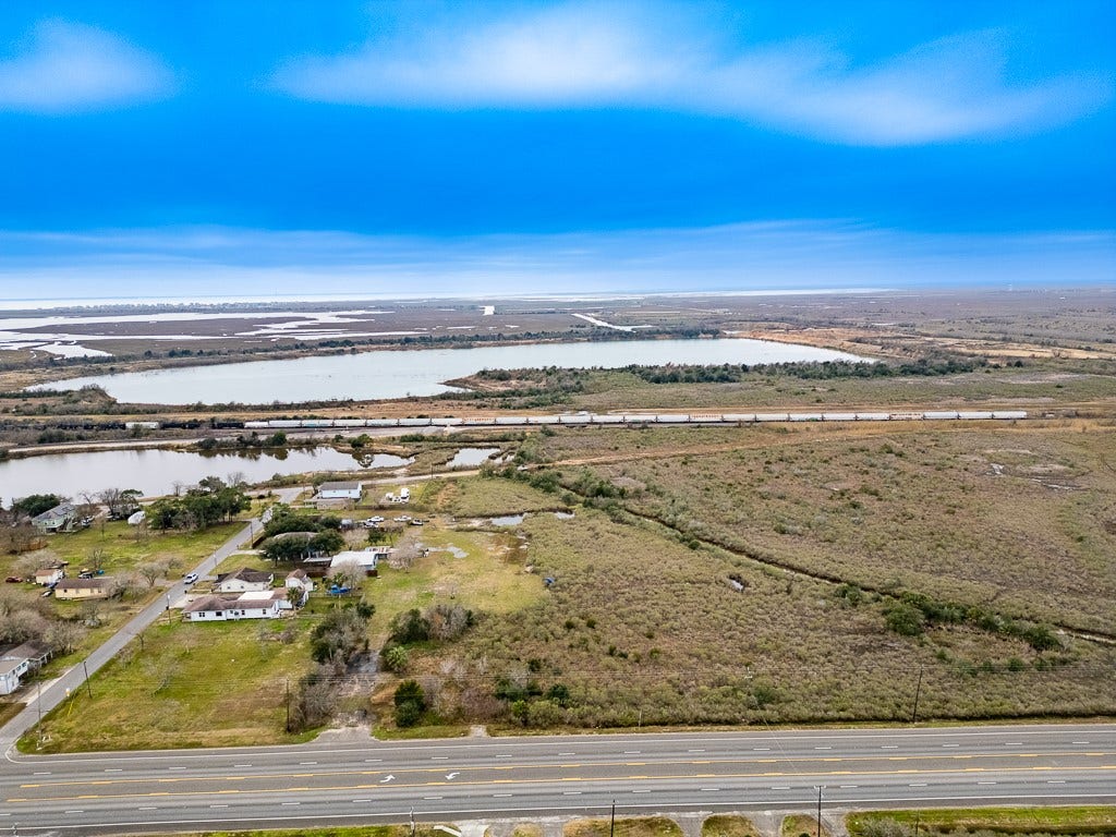 4811 Highway 6, Hitchcock, TX 77563 Aerial view of the property along Highway 6 with nearby waterways and rail corridor visible in the distance.