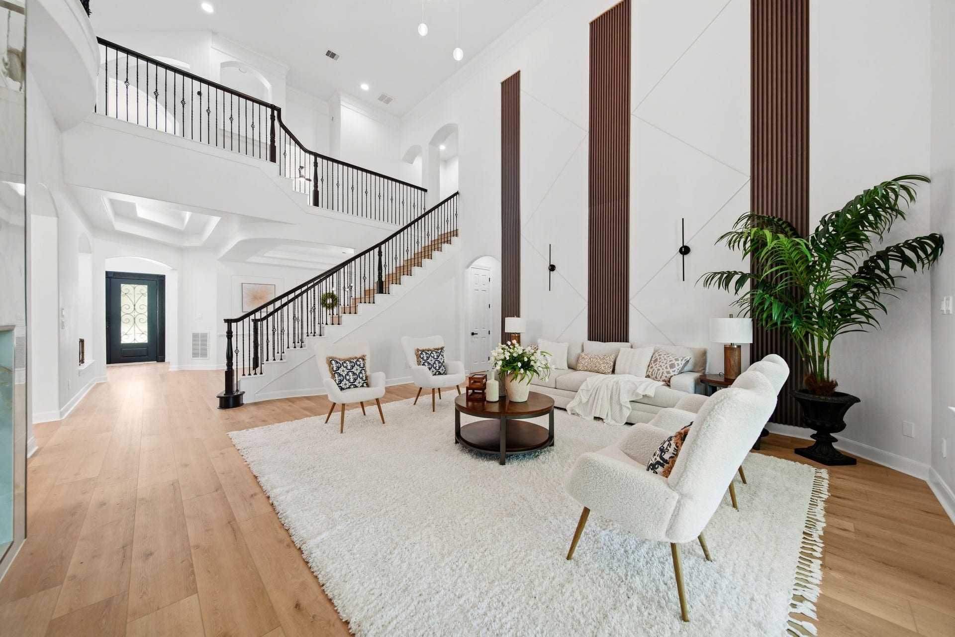 15 Bees Creek Court, Missouri City, TX 77459 Open-concept living space featuring dramatic ceilings, statement wall accents, and ample lighting