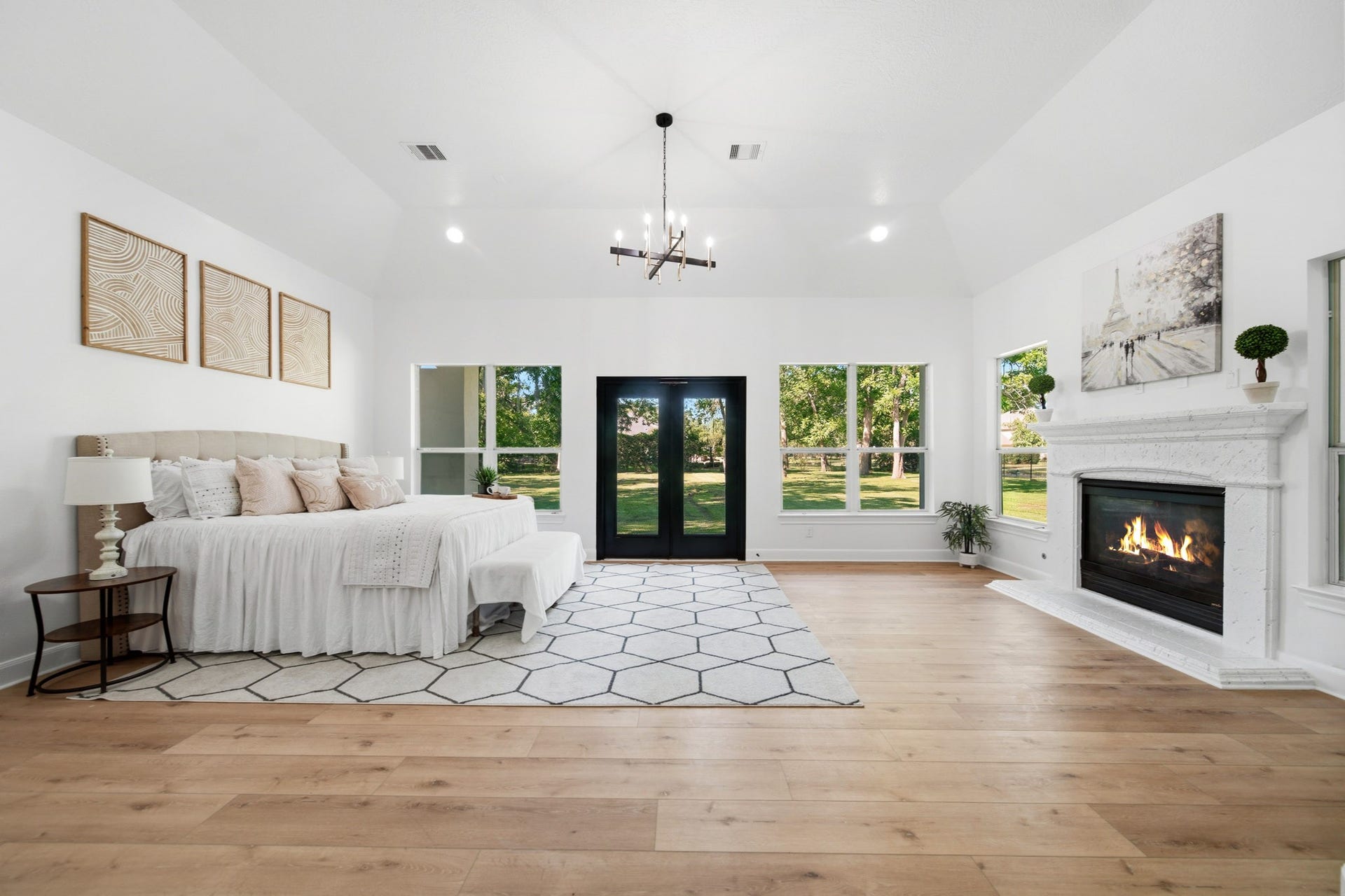 15 Bees Creek Court, Missouri City, TX 77459 Luxurious primary suite with soaring ceilings, fireplace, and serene backyard views.