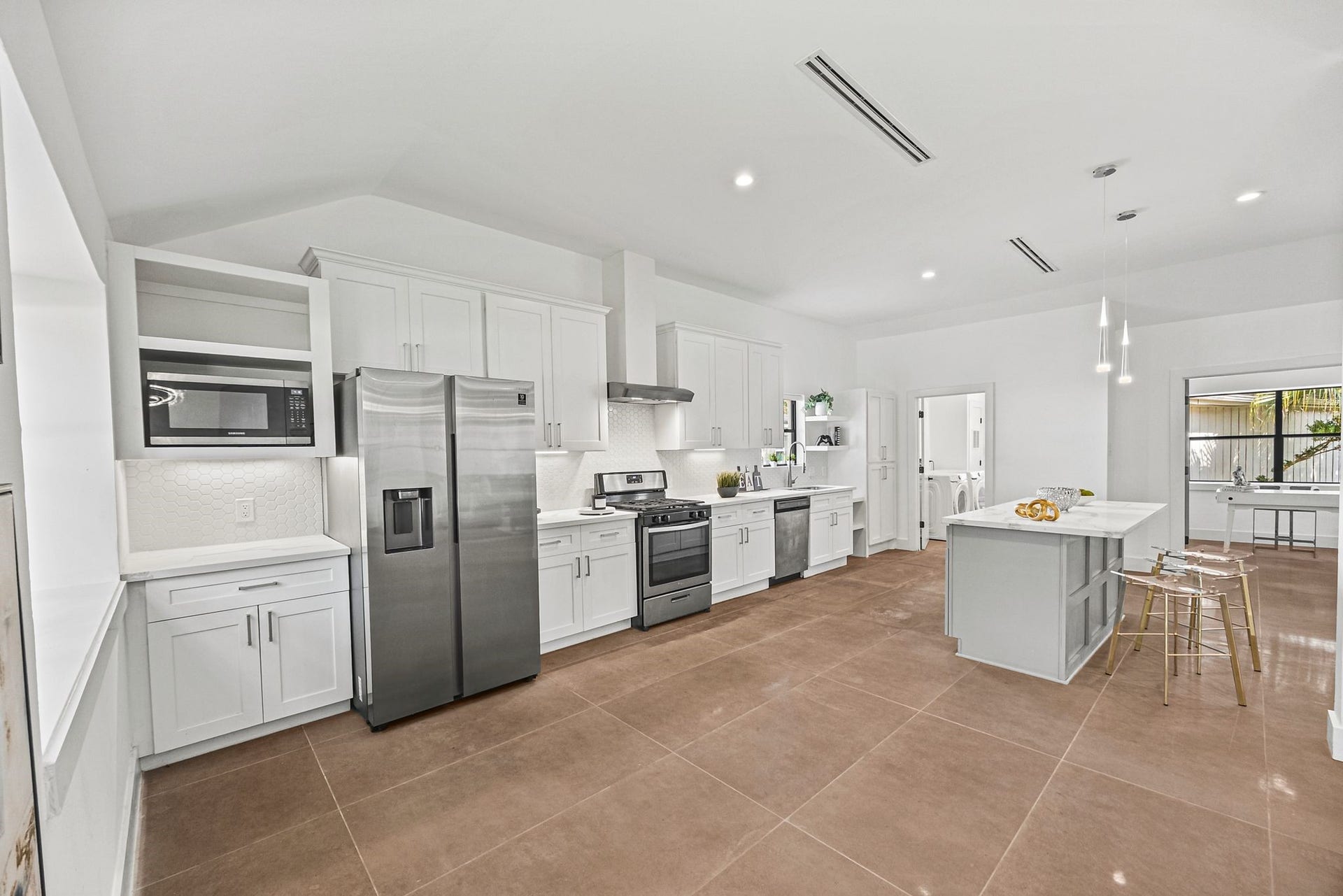 12523 Honeywood Trail, Houston, TX 77077 Spacious kitchen with quartz countertops, stainless steel appliances, white cabinetry, and a center island bar seating.