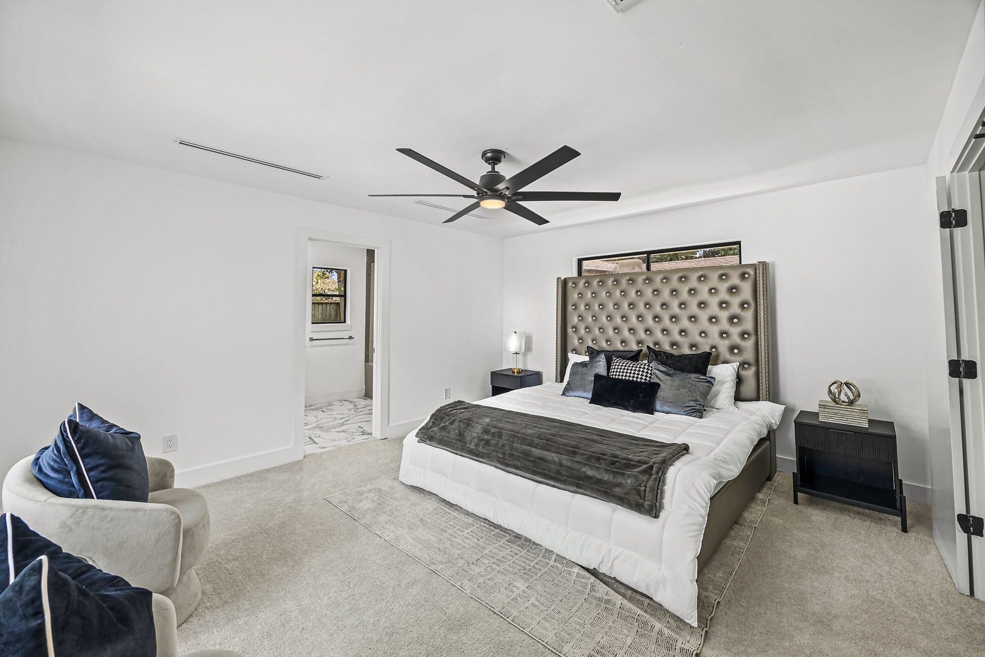 12523 Honeywood Trail, Houston, TX 77077 Primary bedroom featuring a spacious layout, neutral finishes, plush carpeting, and abundant natural light from large windows. The room offers ample space for a king-sized bed and additional furnishings, with direct access to the en-suite bathroom.