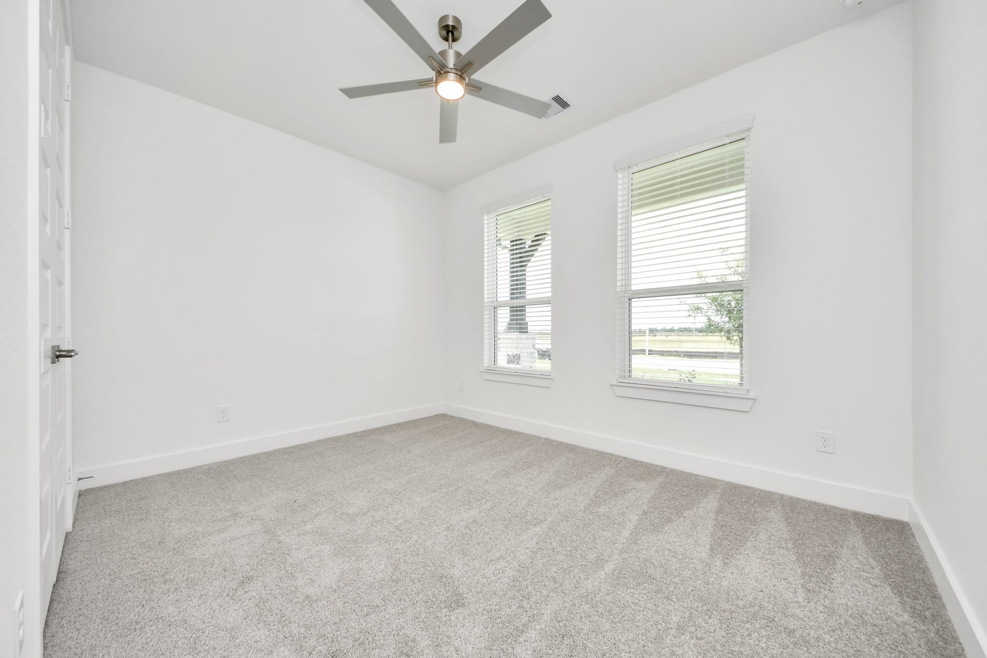24747 Skerne Woods Drive, Spring, TX 77373 Secondary bedroom features plush carpeting, large windows that let in plenty of natural light, bright paint, and spacious closets. Sample photo of completed home with similar floor plan. Actual colors and selections may vary.