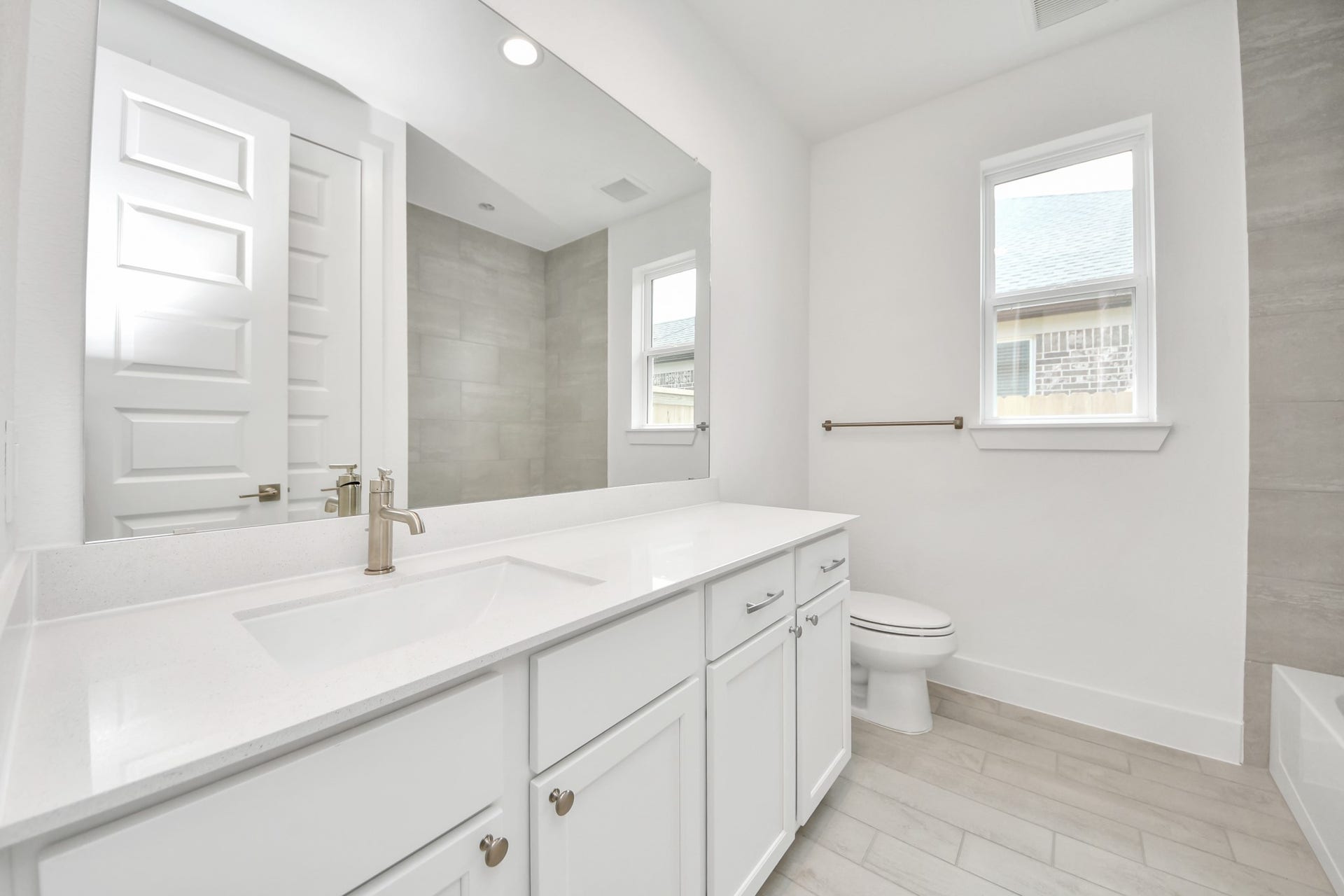 24747 Skerne Woods Drive, Spring, TX 77373 Secondary bath features tile flooring, walk-in shower with tile surround, light stained wood cabinets, beautiful light countertop. Sample photo of completed home with similar floor plan. Actual colors and selections may vary.