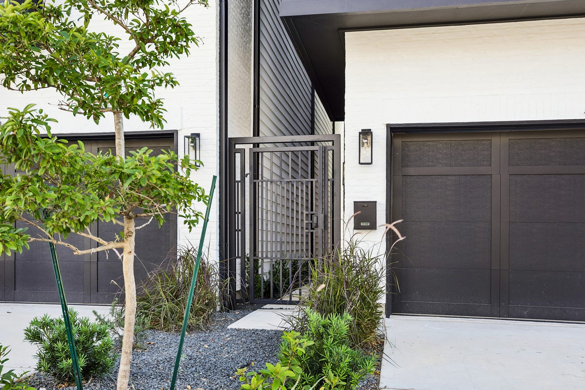 4305 Floyd Street, #B, Houston, TX 77007 Gated front entry features lush landscaping, modern lantern lighting and a sleek garage door.