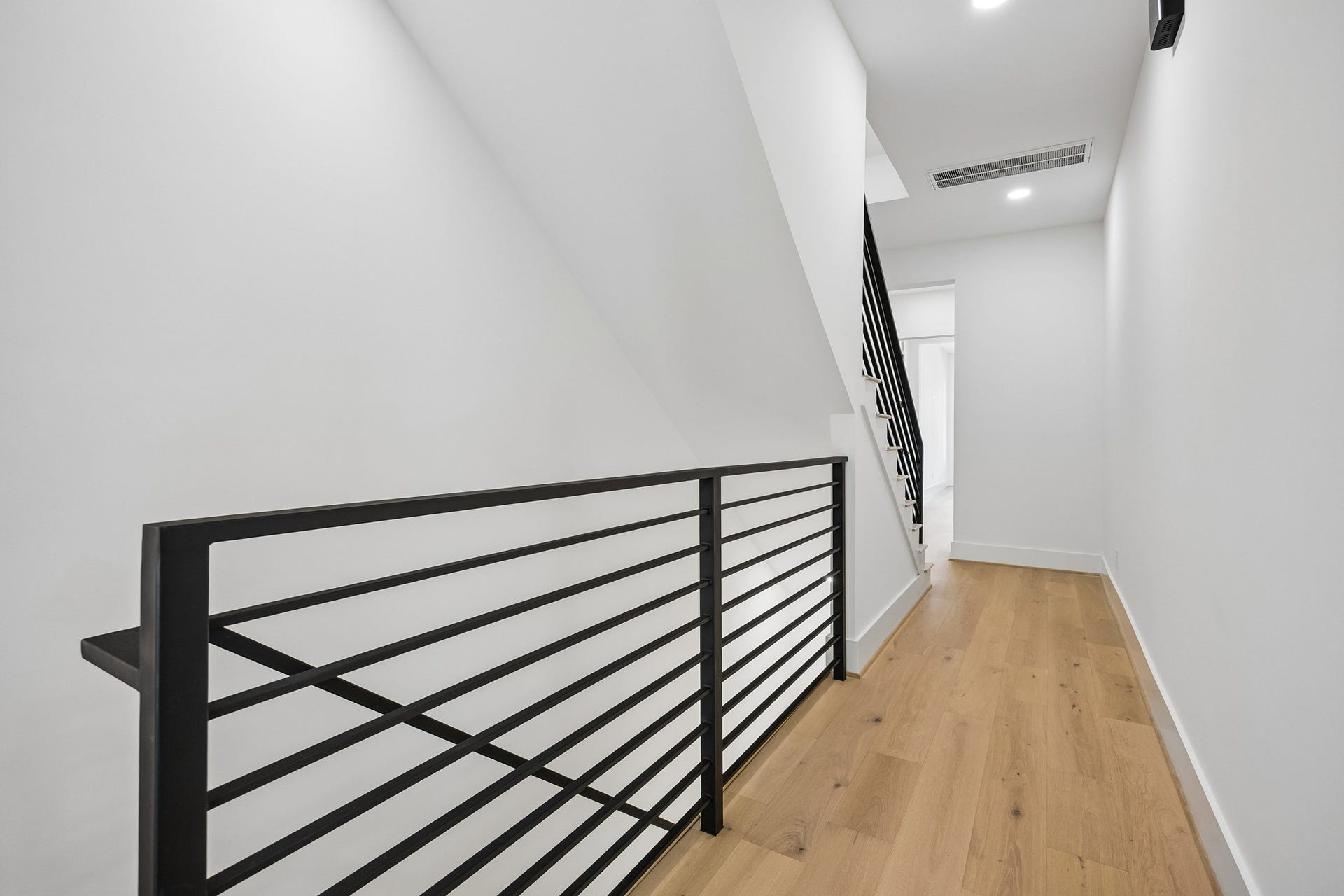 4305 Floyd Street, #B, Houston, TX 77007 Second-floor landing features modern black metal railings and wood flooring.