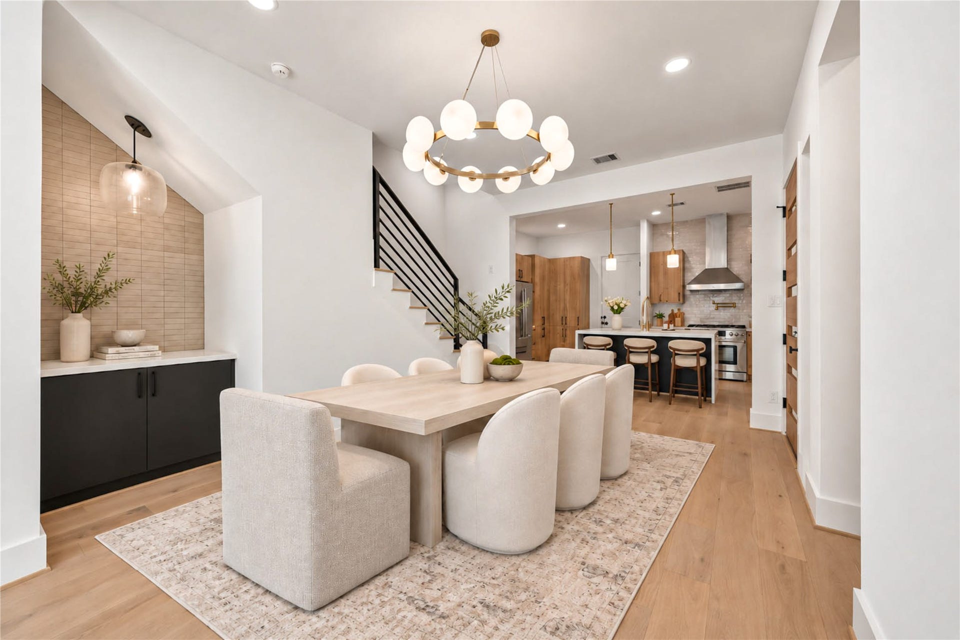 4305 Floyd Street, #B, Houston, TX 77007 Open first floor features a modern globe chandelier, staircase with black metal railing and views of the backyard. (virtual staging)