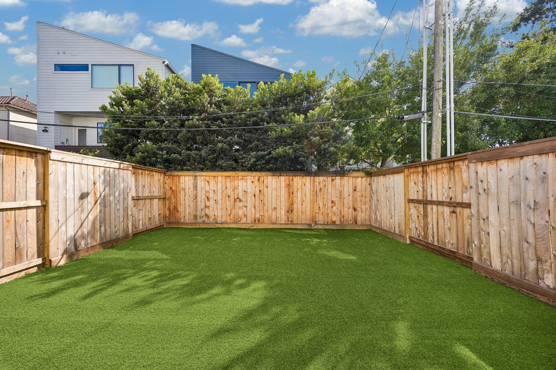 4305 Floyd Street, #B, Houston, TX 77007 Backyard offers privacy, enclosed by wood fencing with mature trees beyond.