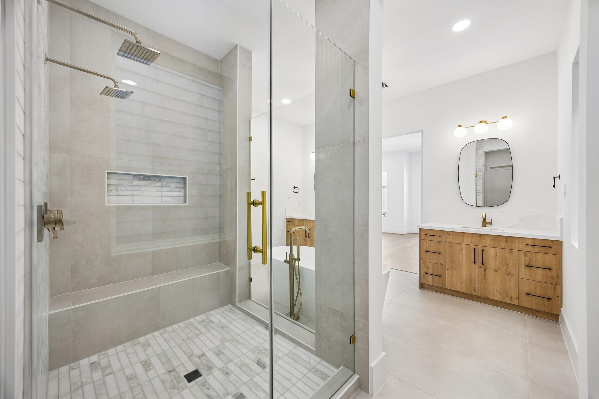 4305 Floyd Street, #B, Houston, TX 77007 Primary shower features a frameless glass enclosure, rain showerhead, built-in bench, and tiled niche.
