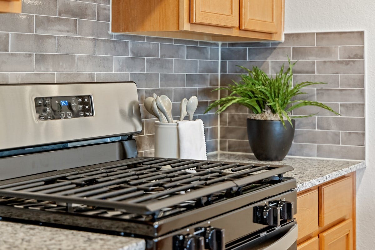 This kitchen has it allample storage, generous counter space, and a layout that truly makes it the heart of the home. Pictured here is the stainless steel Whirlpool gas range and closer views of the gorgeous granite countertop and backsplash.
