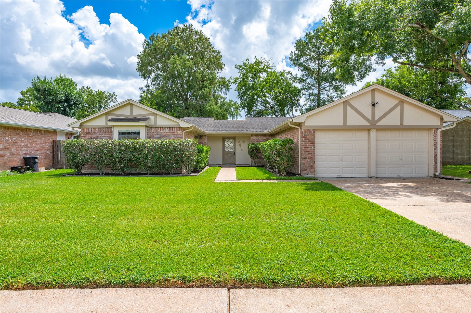 Charming single-story home with a welcoming front lawn, classic brick, and a spacious two-car garage, nestled in a desirable neighborhood.
