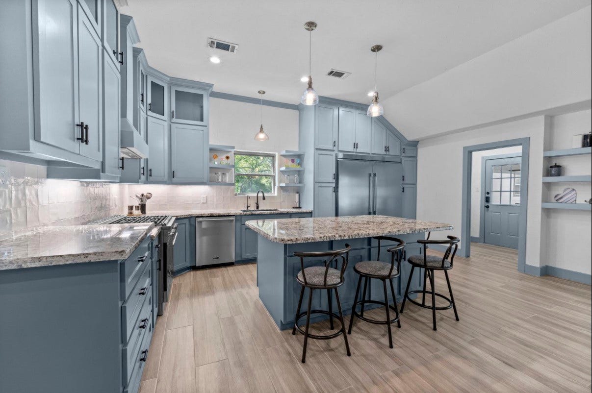 12710 Mutiny Lane, Tomball, TX 77377 Main-house kitchen with a large island, breakfast-bar seating, pendant lighting, and abundant cabinetry.