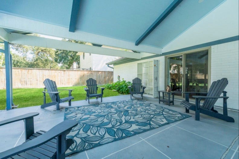 12710 Mutiny Lane, Tomball, TX 77377 Covered outdoor seating area with a vaulted ceiling, exposed beams, and backyard views.