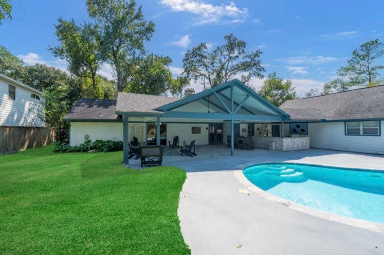 12710 Mutiny Lane, Tomball, TX 77377 Rear view of the home showcasing the covered patio, outdoor kitchen, and pool.