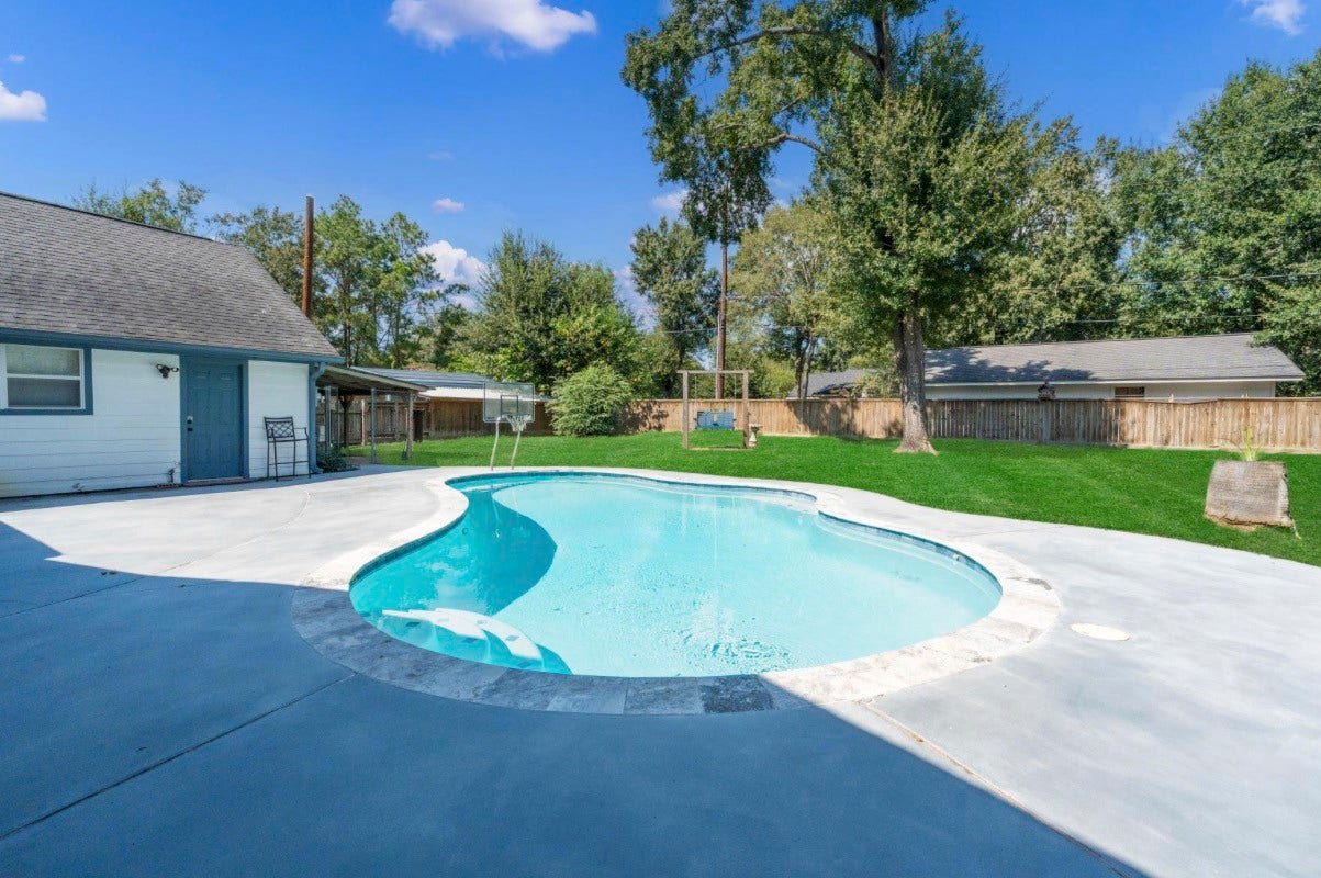 12710 Mutiny Lane, Tomball, TX 77377 Pool view looking toward the fenced backyard and mature trees.