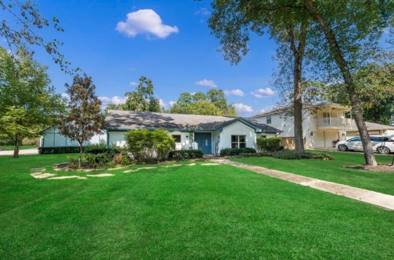 12710 Mutiny Lane, Tomball, TX 77377 Mature trees and a broad lawn surround the home.