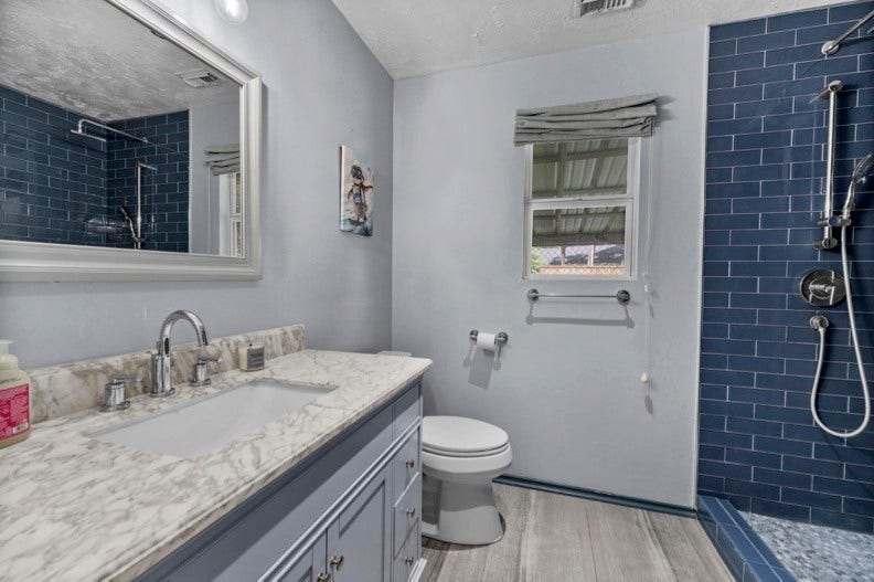 12710 Mutiny Lane, Tomball, TX 77377 Additional main-house bathroom with a vanity, window, and blue-tiled shower.