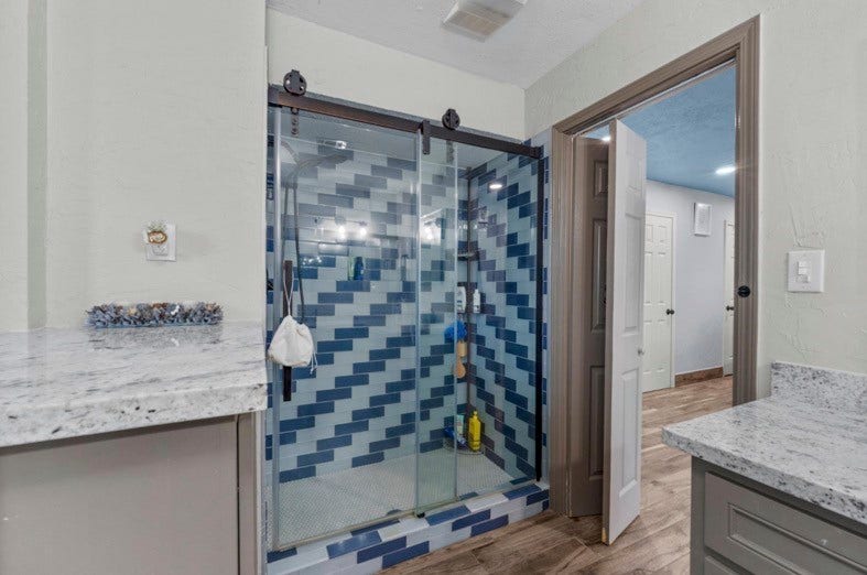 12710 Mutiny Lane, Tomball, TX 77377 Glass-enclosed shower with distinctive blue tile detailing.